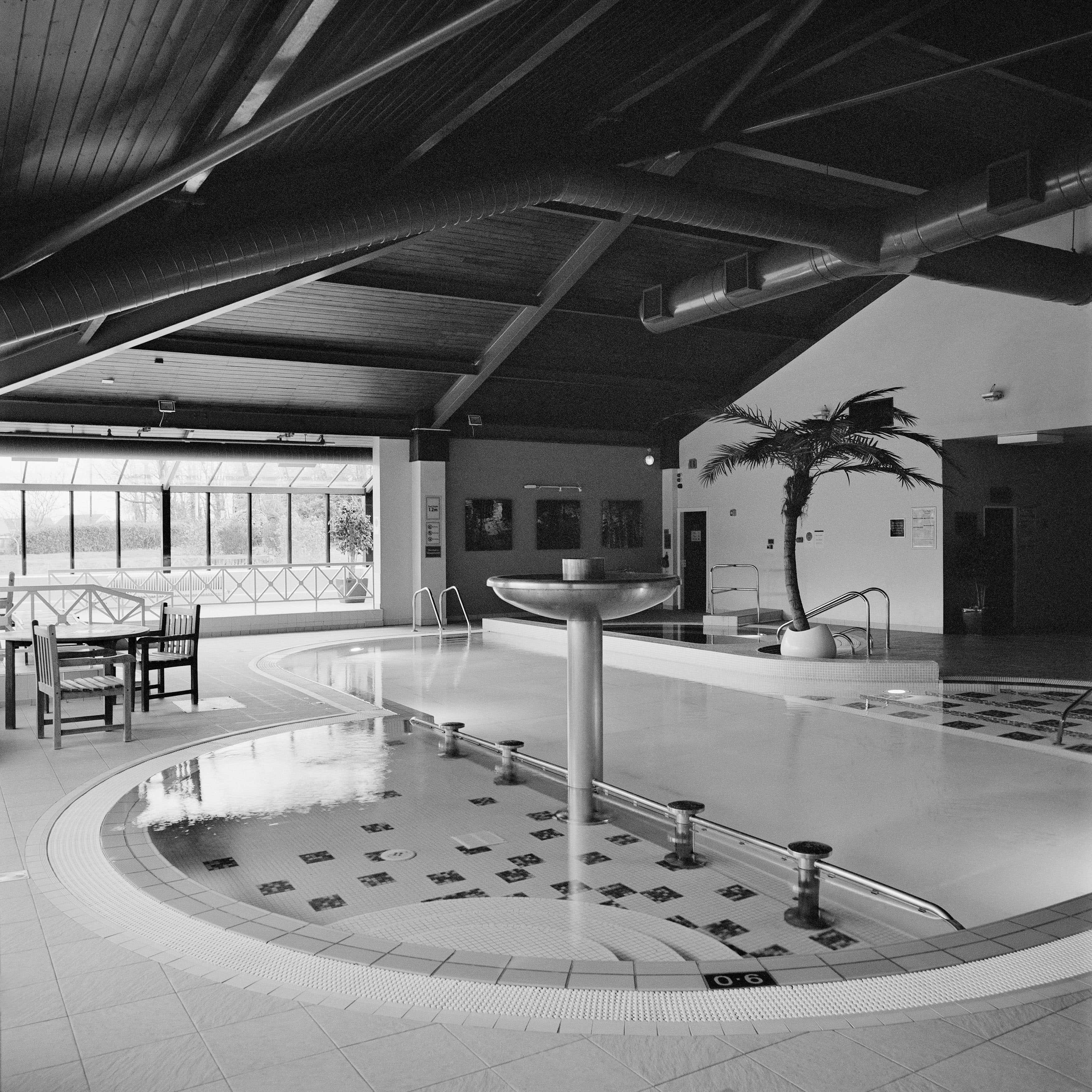 Fotografia architettonica monocromatica quadrata: Design di una piscina con fontana