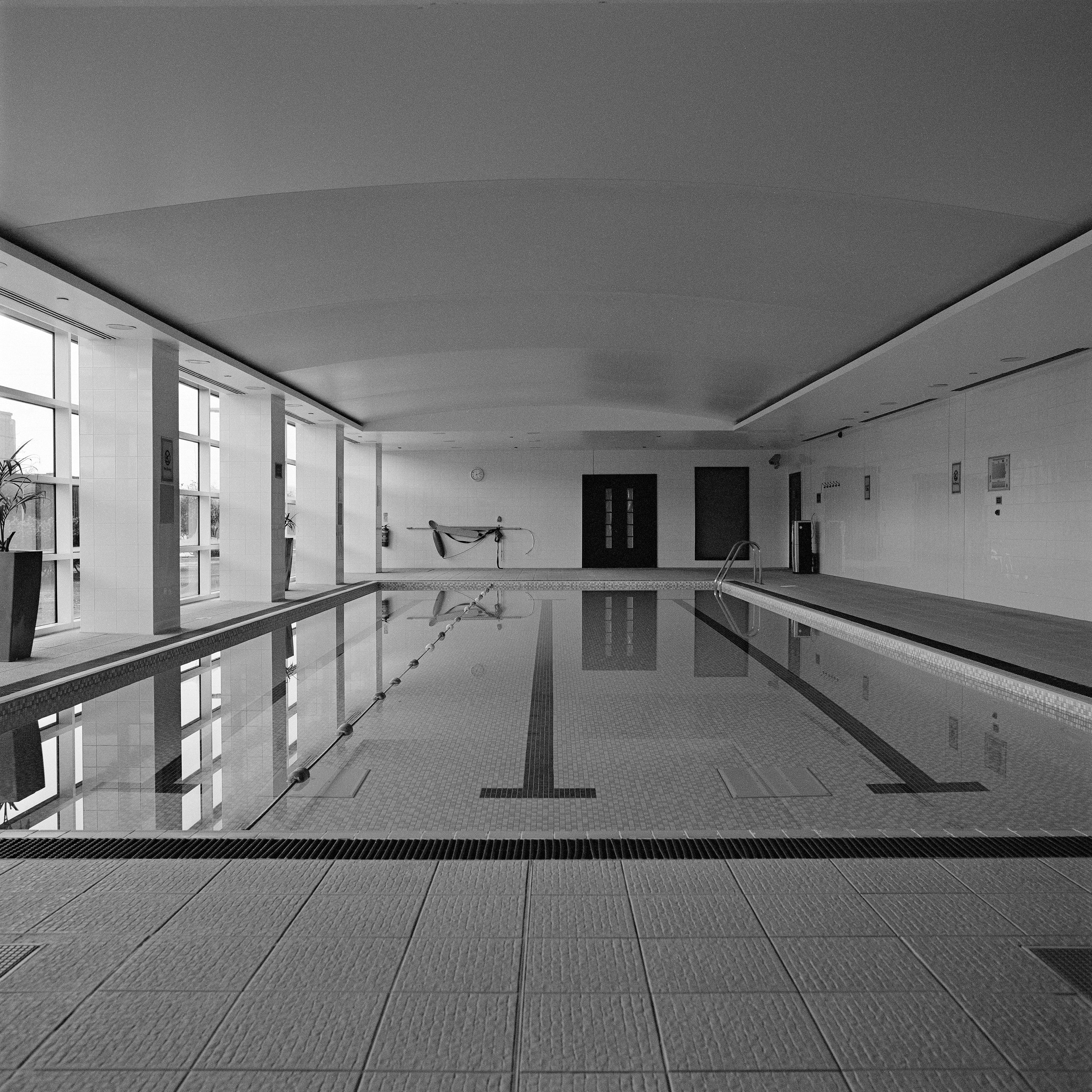 Anna Dobrovolskaya-Mints Black and White Photograph – Monochrome quadratische Architekturfotografie: Swimming Pool Design