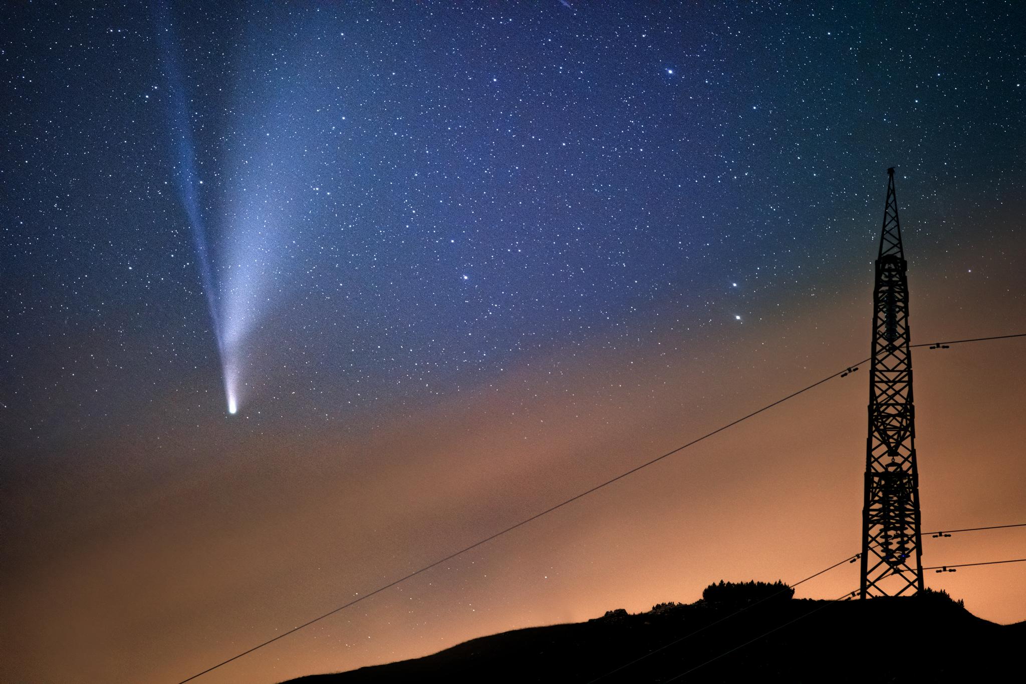 Comet approaches the Earth. Color night photo in a black wooden frame with glass