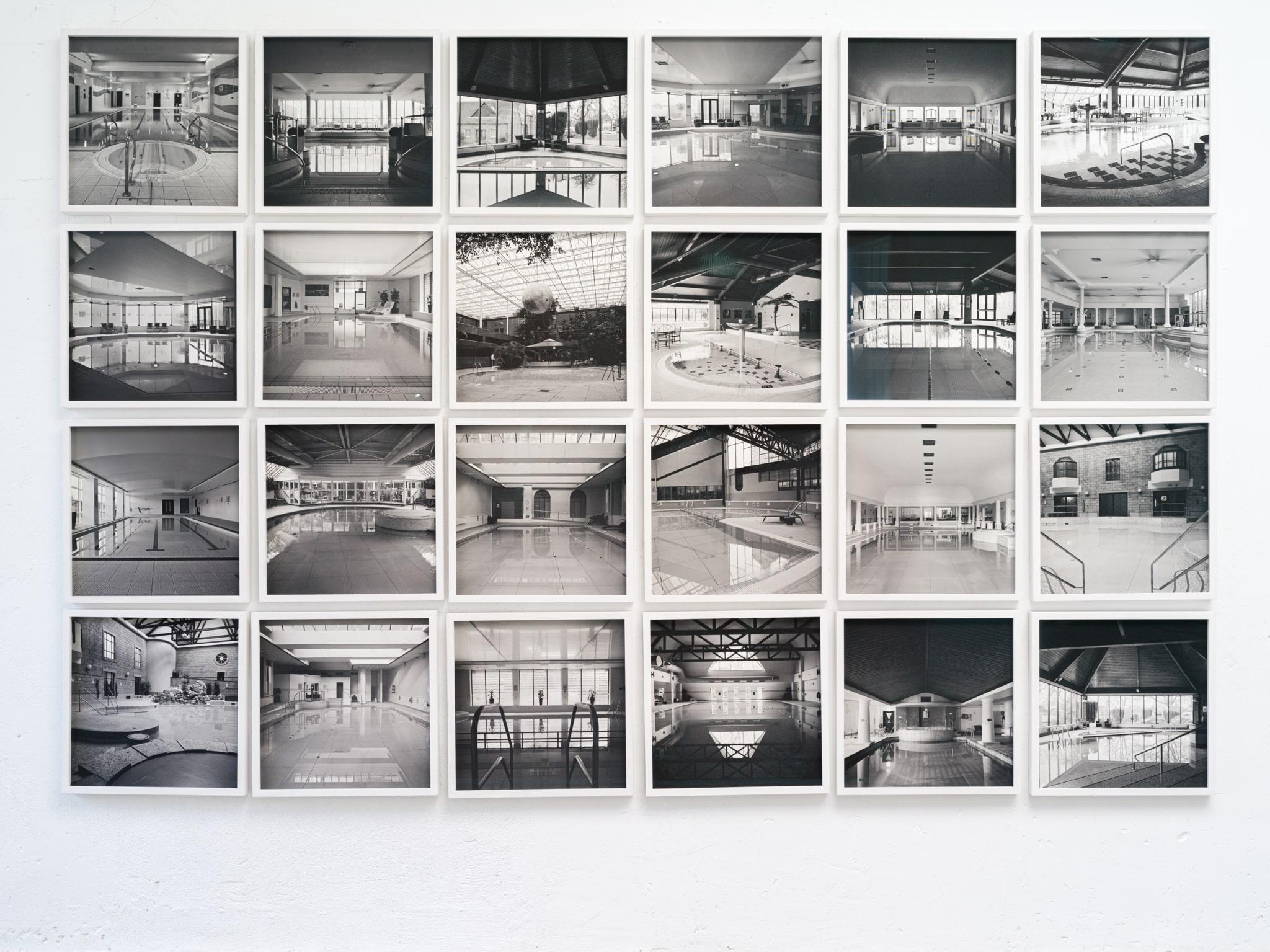 Large panel of black and white architecture photos in white frames with glass