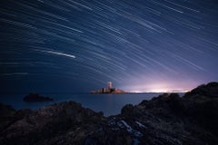 Star-trails über einem Schloss in Frankreich. Blaues gerahmtes Foto mit Museumsglas