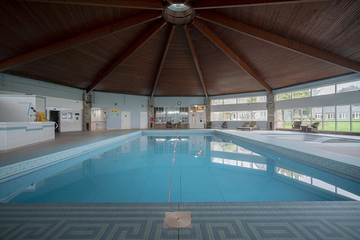 Architectural photo of a pool in a hotel in Wales. White frame, museum glass