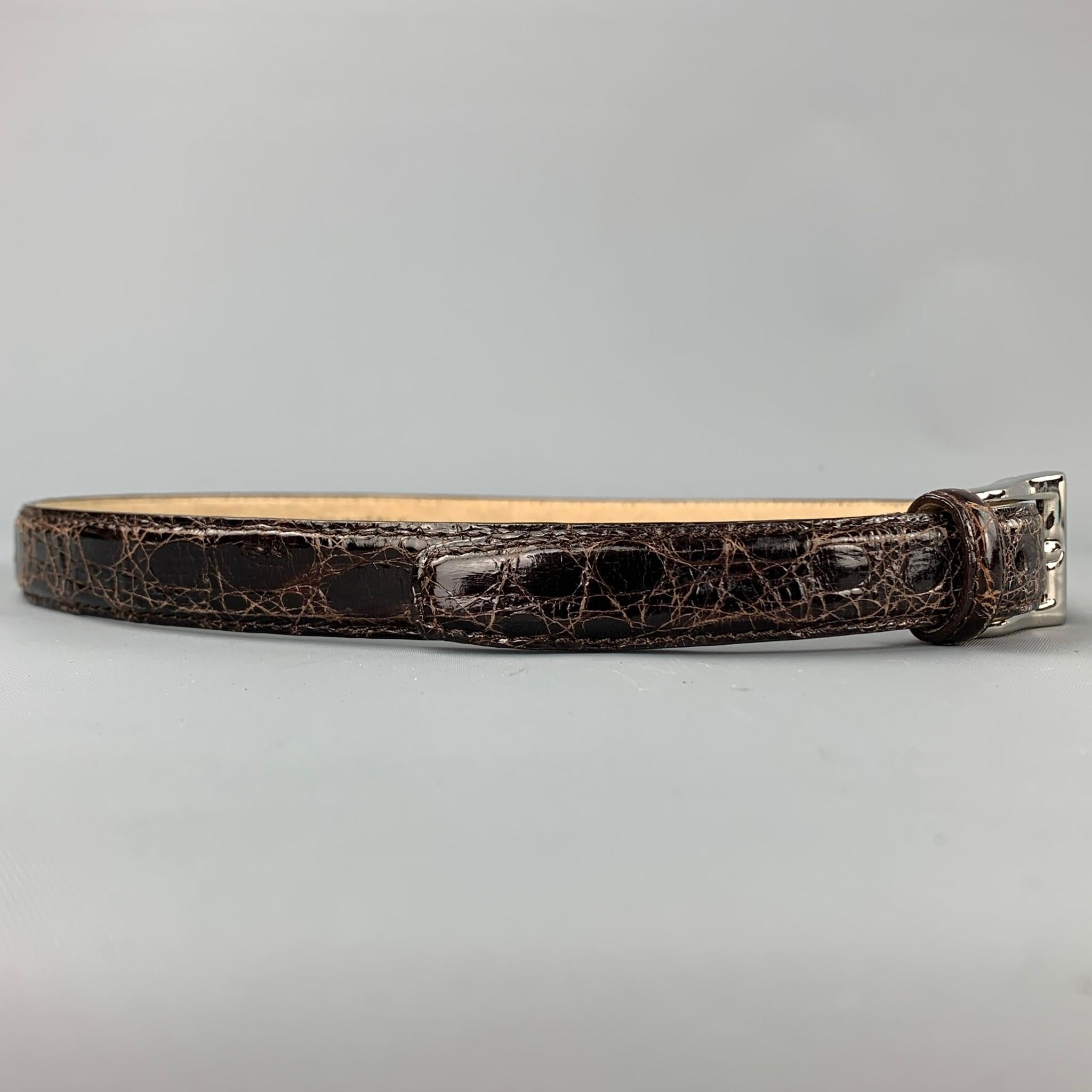 ANNA FIRENZE belt comes in a olive alligator leather featuring a skinny style and a silver tone buckle. Made in Italy.

Very Good Pre-Owned Condition.
Marked: 85/70

Length: 33.5 in.
Width: 1 in.
Fits: 24 in. - 28 in.
Buckle: 1.5 in. 