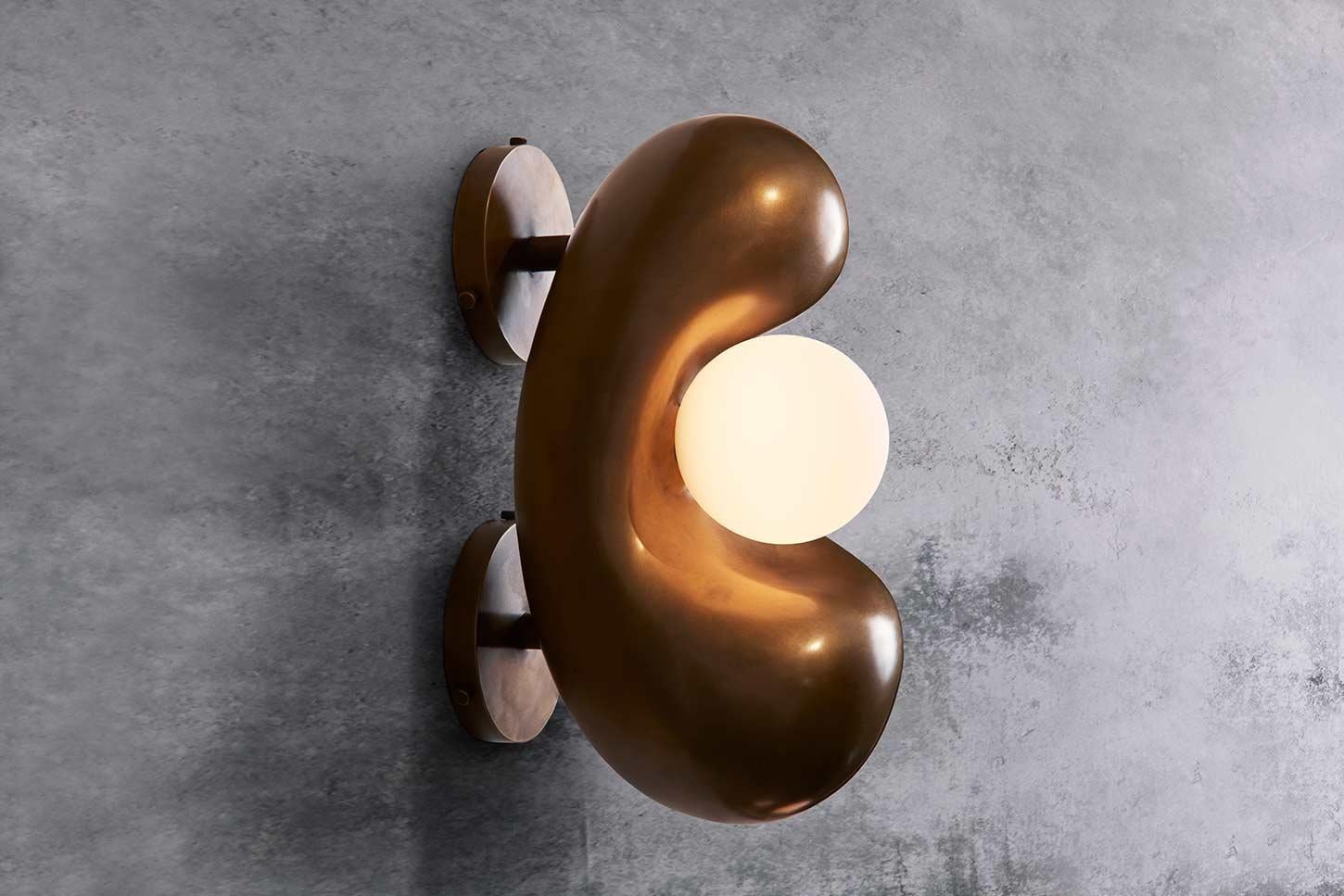 An organic clay sculpture that has been cast in hot-patinated bronze. The addition of hand-blown glass completes this sculptural light form. 