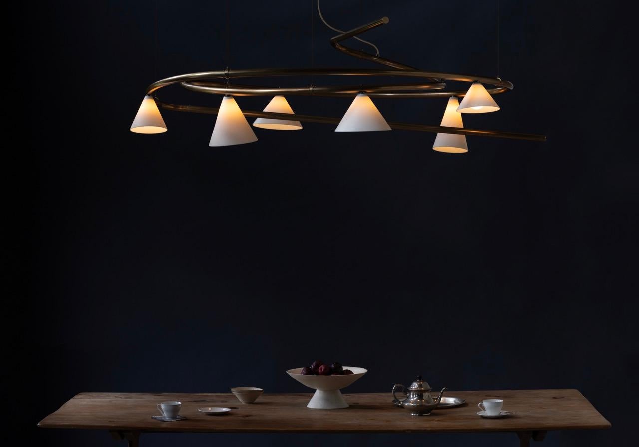 It is as the name suggests, a sketch brought to life. Glowing porcelain shades made in England hang from its metal structure. Inside each shade, a hand blown white glass teardrop houses the light source. 

  