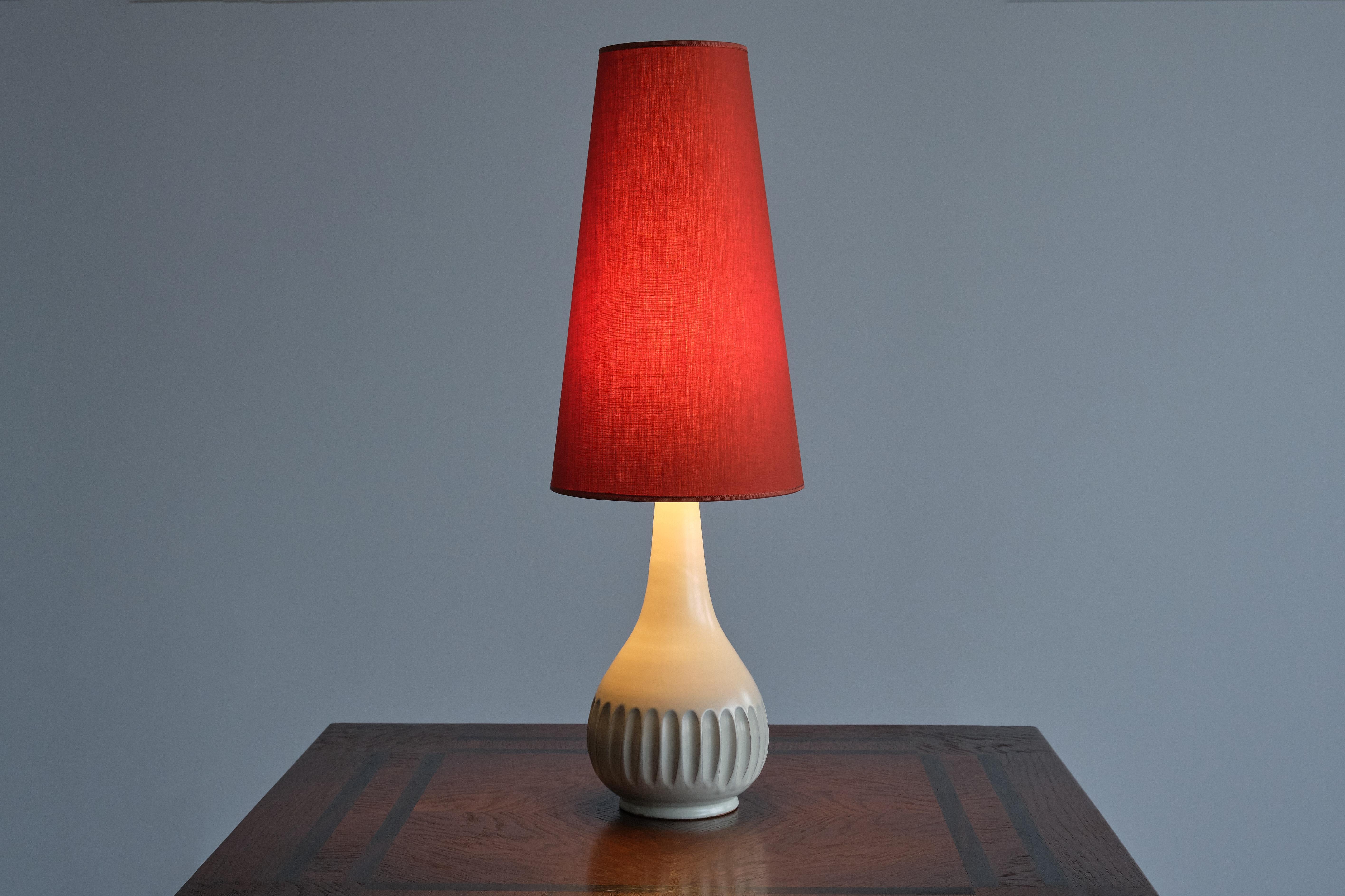 Cette élégante lampe de table a été conçue par la peintre et céramiste suédoise Anna-Lisa Thomson. La base a été produite par le fabricant de céramique et de porcelaine Upsala-Ekeby à la fin des années 1940. La lampe est estampillée 