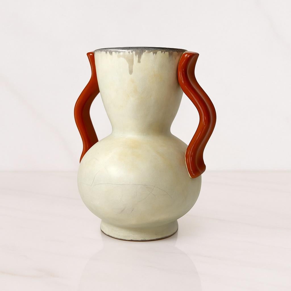 Rare vase en céramique conçu par Anna-Lisa Thomson pour Uppsala Ekeby, Suède, vers les années 1940. Le vase présente une forme gracieuse de double gourde accentuée par des poignées incurvées sculpturales dans une glaçure chaude brun-rouge. Le corps