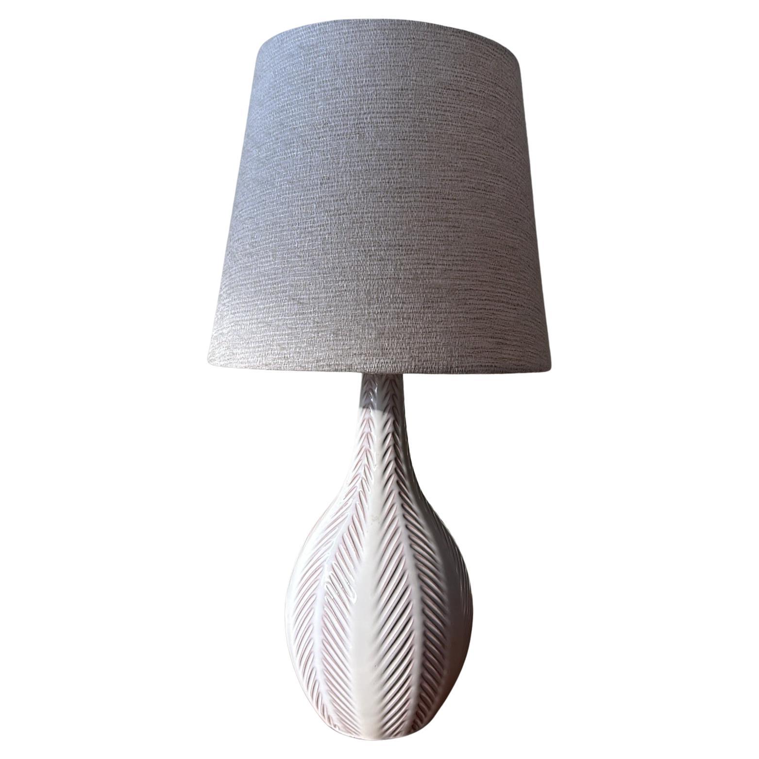 Lampe de table en faïence à glaçure blanche conçue par Anna-Lisa Thomson et produite par Upsala-Ekeby, Suède, années 1940.  Belle texture en forme d'arête de poisson.
L'abat-jour en cachemire de couleur crème fait par l'atelier est inclus.
Nouveau