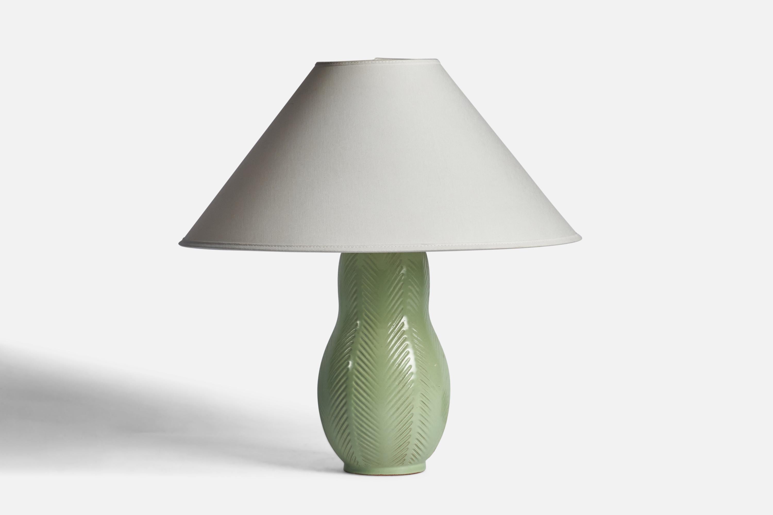 A green-glazed and incised table lamp designed by Anna-Lisa Thomson and produced by Upsala Ekeby, Sweden, 1930s.

Dimensions of Lamp (inches): 12.15 H x 5.25” Diameter
Dimensions of Shade (inches): 4.5” Top Diameter x 16” Bottom Diameter x 7.25”