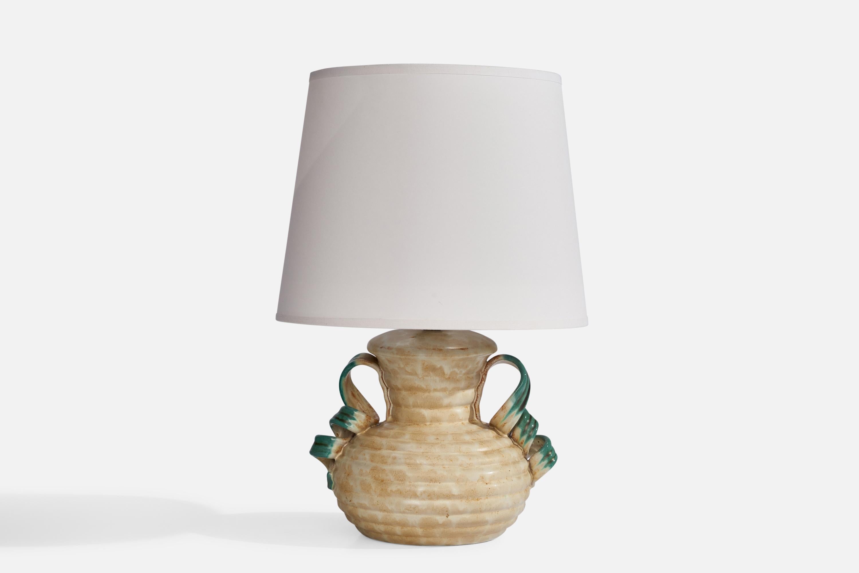 A green and beige-glazed earthenware table lamp designed by Anna-Lisa Thomson and produced by Upsala Ekeby, Sweden, 1930s.

Dimensions of Lamp (inches): 9” H x 8” W x 6” Depth
Dimensions of Shade (inches): 8” Top Diameter x 10” Bottom Diameter x 8”