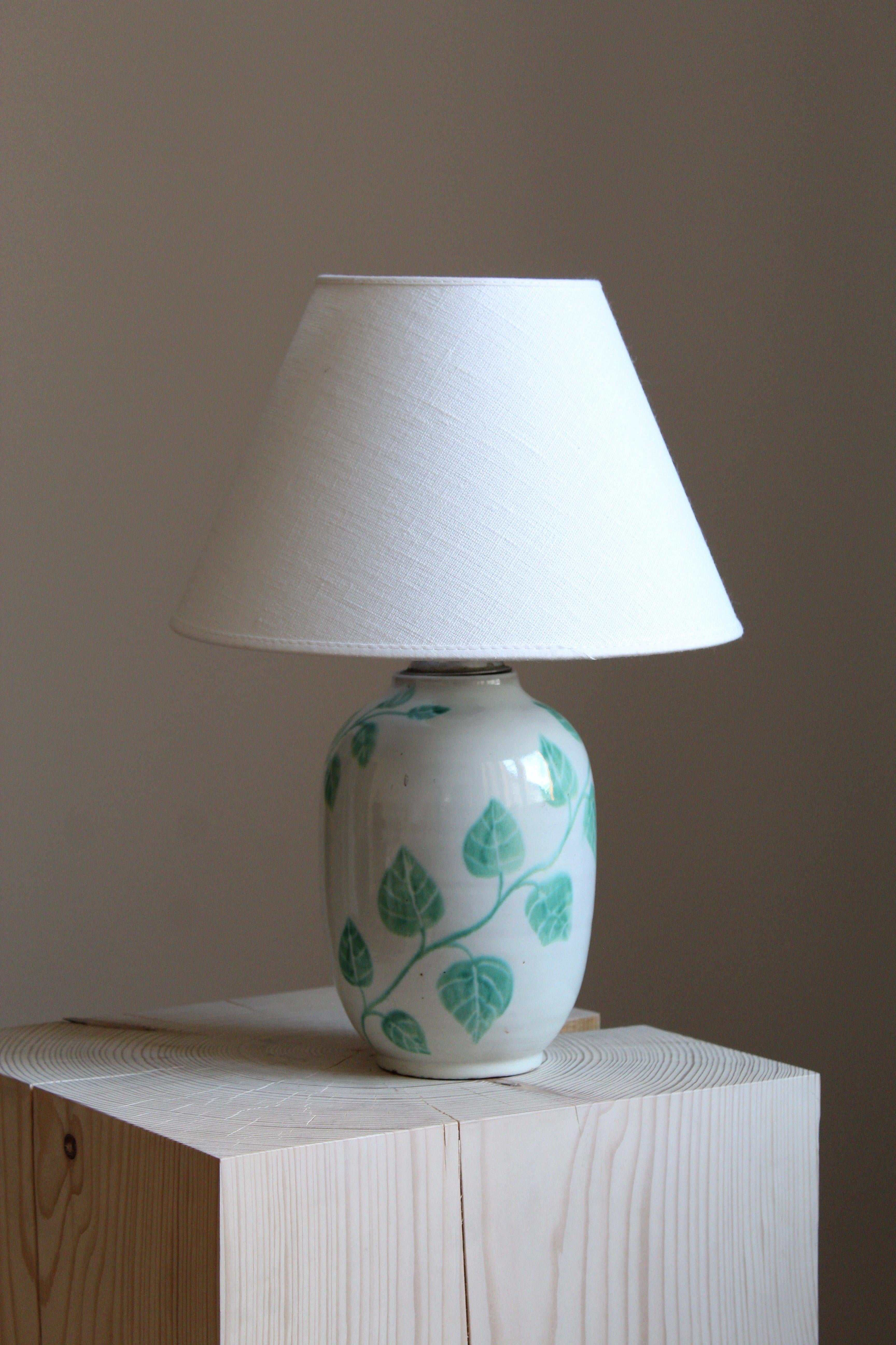 An early modernist table lamp. Designed by Anna-Lisa Thomson, for Upsala-Ekeby, Sweden, 1940s. With stamp including artist's initials. Sold without lampshade.

Glaze features white-green colors.

Other designers of the period include Ettore