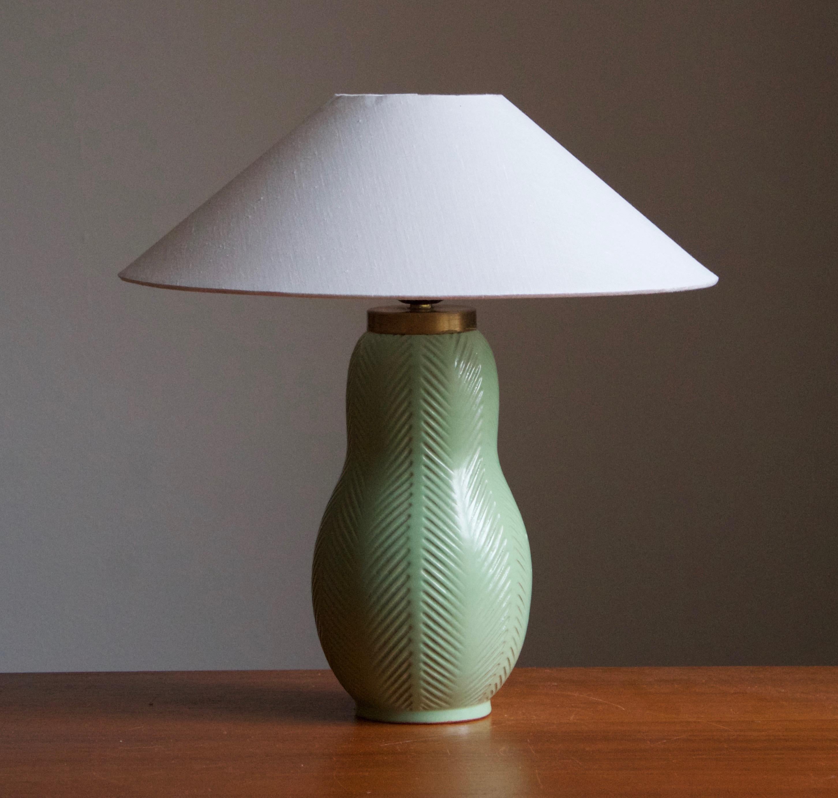 An early modernist table lamp. Designed by Anna-Lisa Thomson, for Upsala-Ekeby, Sweden, 1940s. Presents a gourd shape with finely incised fluted decoration.

Stated dimensions exclude lampshade. Height includes socket. Lampshade is not included in