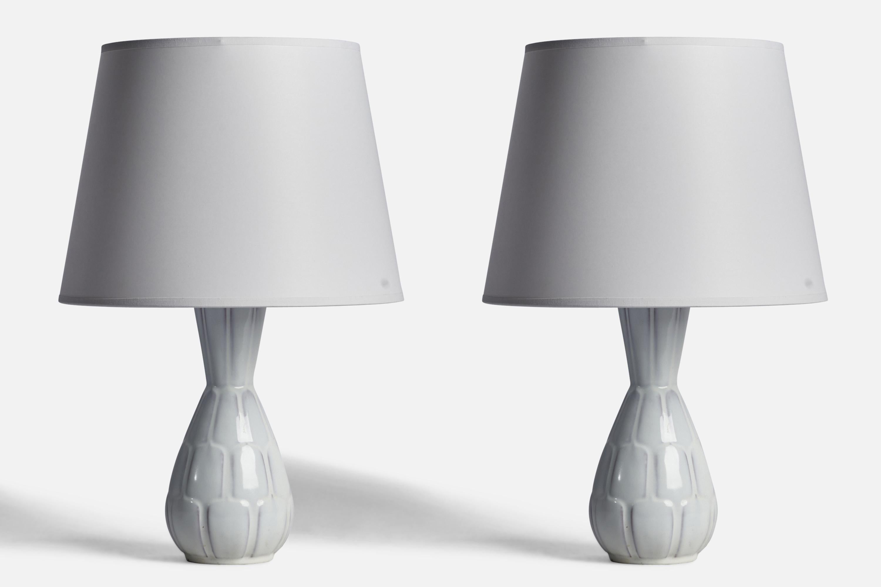 A pair of white-glazed earthenware table lamps designed by Anna-Lisa Thomson and produced by Upsala Ekeby, Sweden, 1930s.

Dimensions of Lamp (inches): 12” H x 4.5” Diameter
Dimensions of Shade (inches): 8.75” Top Diameter x 12” Bottom Diameter x 9”