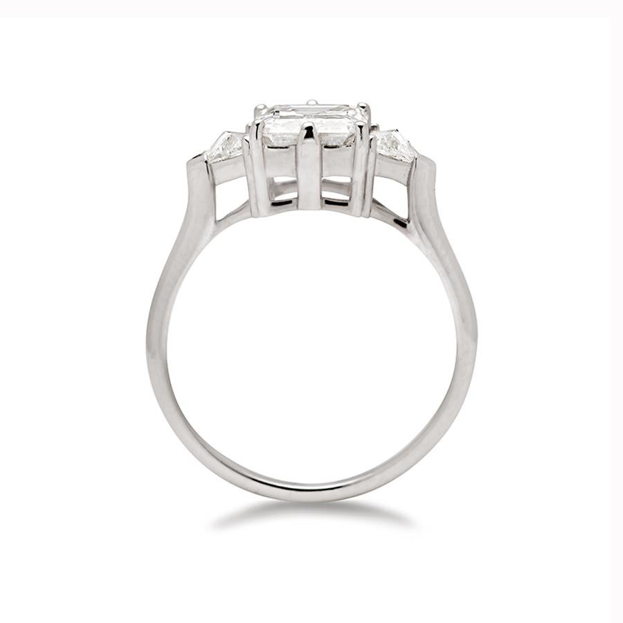 1.80ct (F/VS1) emerald cut white diamond center set with 0.22ctw white diamond trillions in 14k recycled white gold.

This Bea Three Stone Ring in white gold features a stunning emerald cut diamond center. The center stone is set in our AS