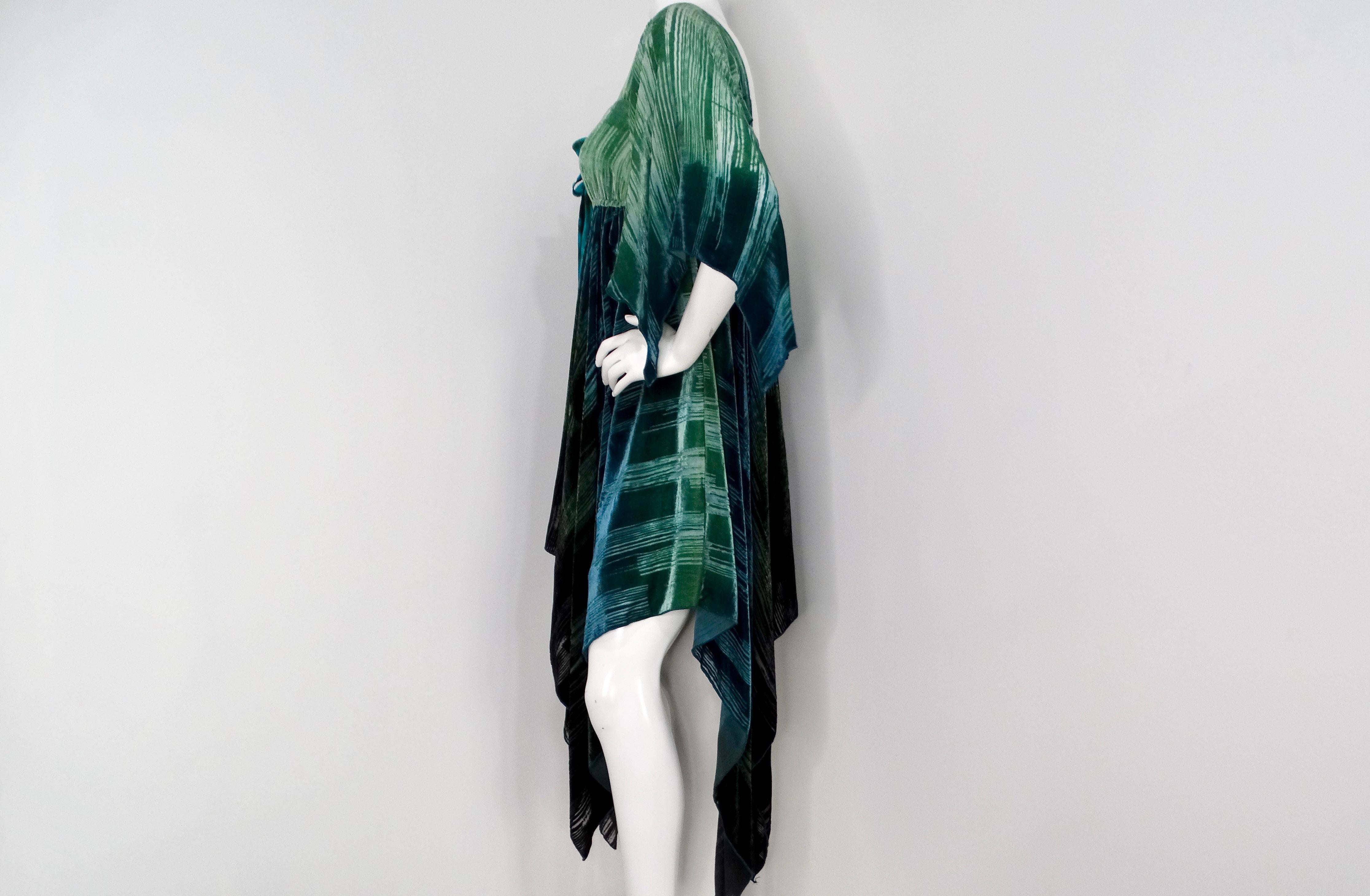 The Anna Sui 2000s Teal Handkerchief Midi Dress is a captivating blend of rich greens and blues, crafted from a felt material that offers both comfort and style. The dress features a unique striped abstract print that evokes a sense of artistic