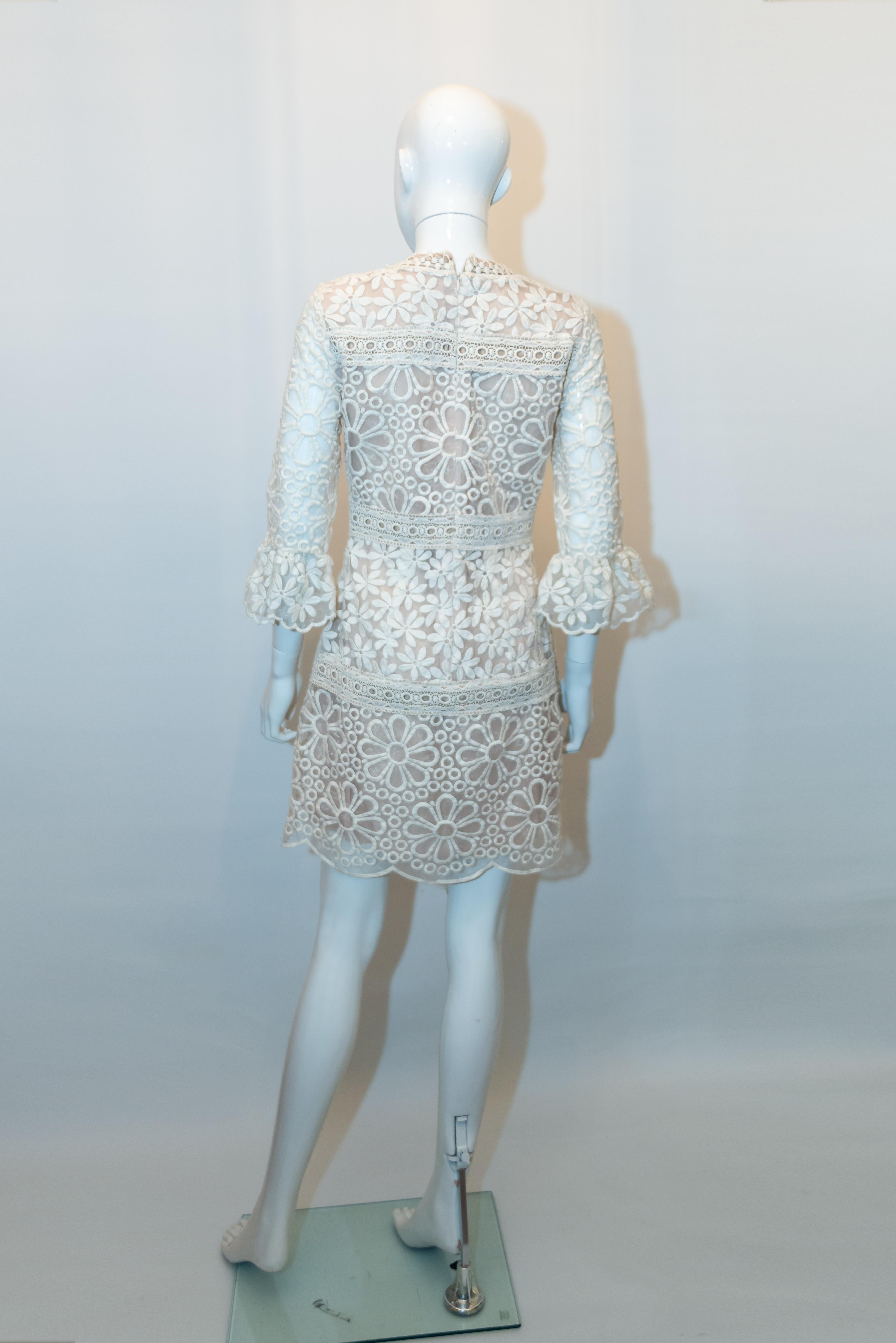 A fun frock by Anna Sui, perfect for a party or a wedding. The dress has a round neckline, elbow length sleaves and scallop hem. The outer fabric is a silk mix, heavy lace like and hangs beautifully. US suze 4, Bust 36'', length 35''