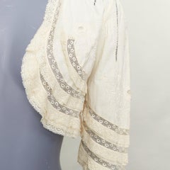 ANNA SUI – cremefarbene Bolerojacke aus Baumwolle mit aufwendiger Spitzenstickerei in Blumenmuster und Rüschen