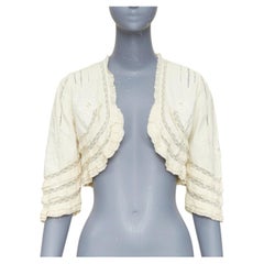 ANNA SUI – cremefarbene Bolerojacke aus Baumwolle mit aufwendiger Spitzenstickerei in Blumenmuster und Rüschen