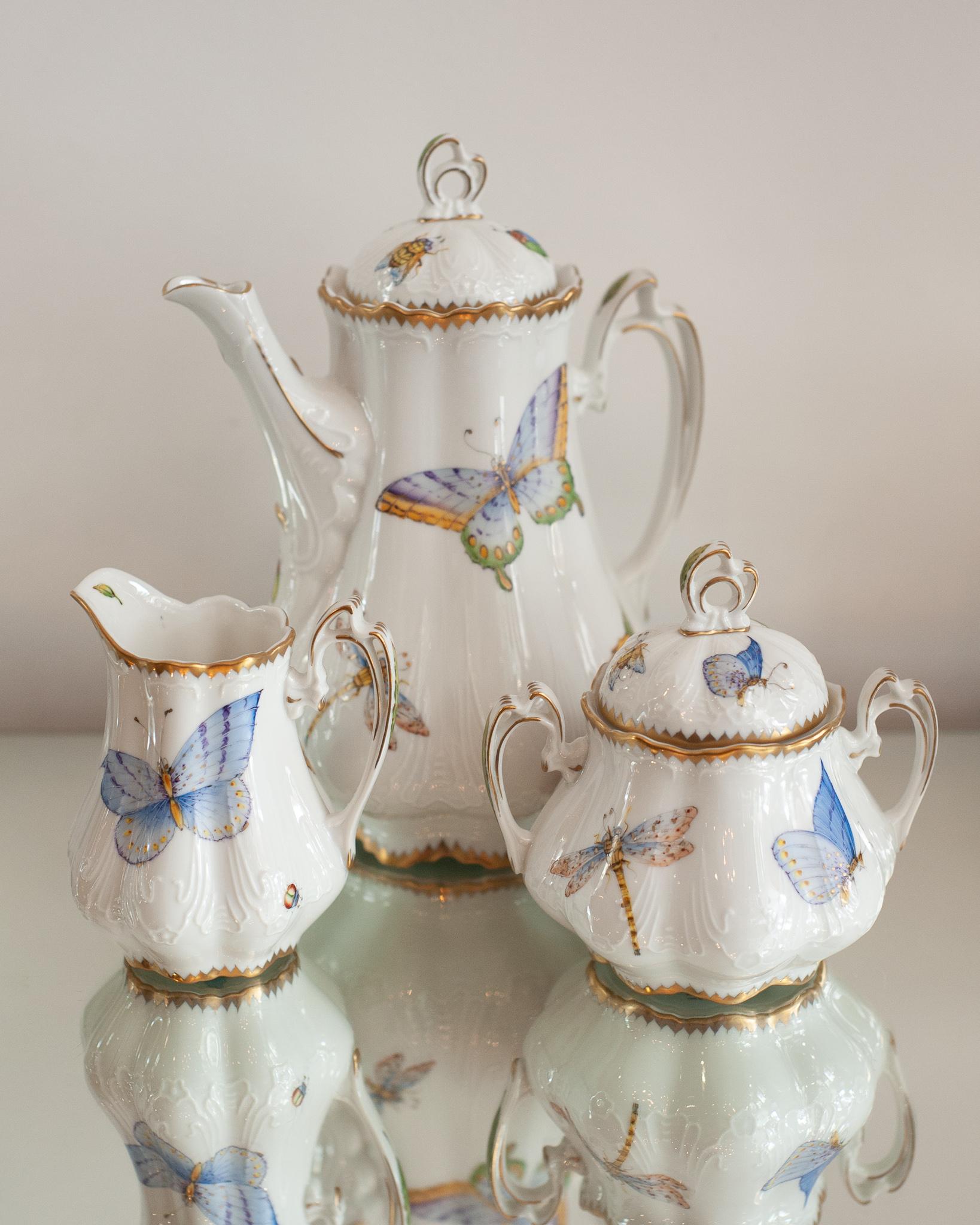 Ein wunderschönes dreiteiliges Kaffee-/Teeset, handbemalt mit Schmetterlingen von Anna Weatherley Designs. Anna Weatherley entwirft und produziert seit 30 Jahren feines botanisches handbemaltes Porzellan in Ungarn.

Teekanne misst 10