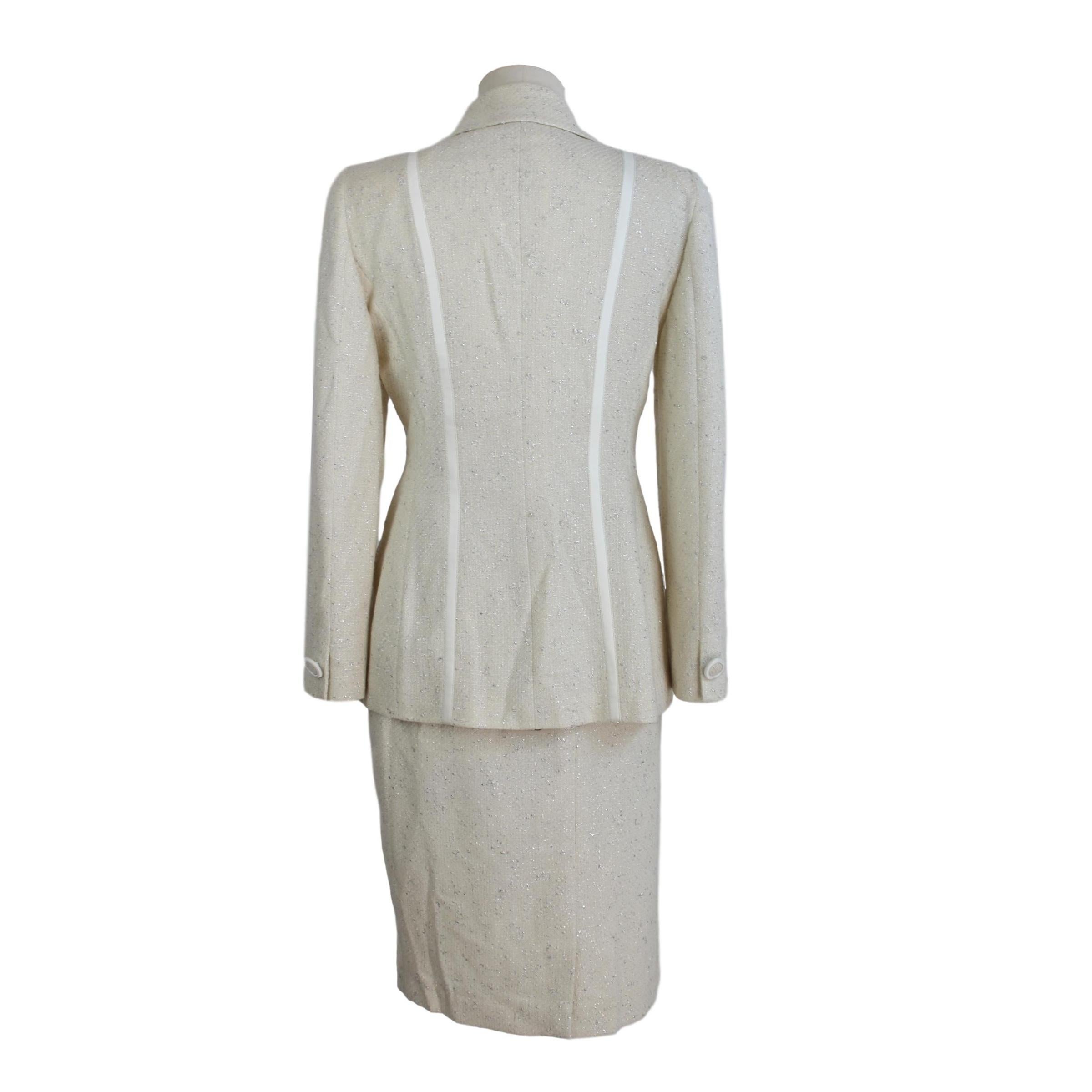 Annalisa Ferro eleganter Anzugrock für Damen. Anzug bestehend aus Jacke und Rock, 58% Wolle 25% Baumwolle 9% Polyamid 8% Polyester. Weiße Farbe mit silbernen Fäden. Die Jacke wird mit zwei Knöpfen geschlossen. Langer Rock auf Mantelknie. Hergestellt