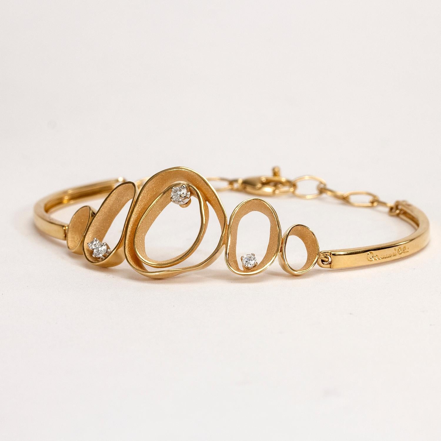 De la collection Essential d'Annamaria Cammilli, le bracelet Dune est fabriqué à la main en or orange 18 carats. Quatre diamants blancs brillants d'un poids total de 0,23 carat. Deux cercles extérieurs incurvés et un élément à double couche incurvée