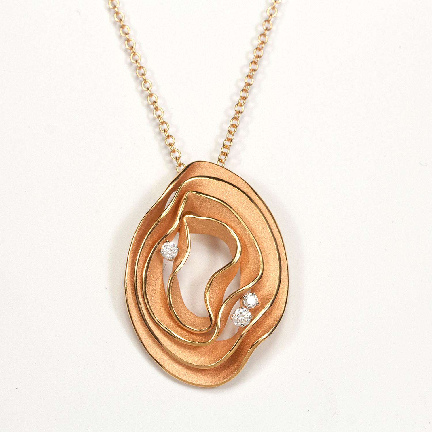 Dalla collezione Dune Electa di Annamaria Cammilli, collana con ciondolo realizzata a mano in oro rosa champagne 18 carati. Quattro strati di oro lucido e satinato, con tre diamanti incastonati tra gli strati. Il peso totale dei diamanti è di 0,16