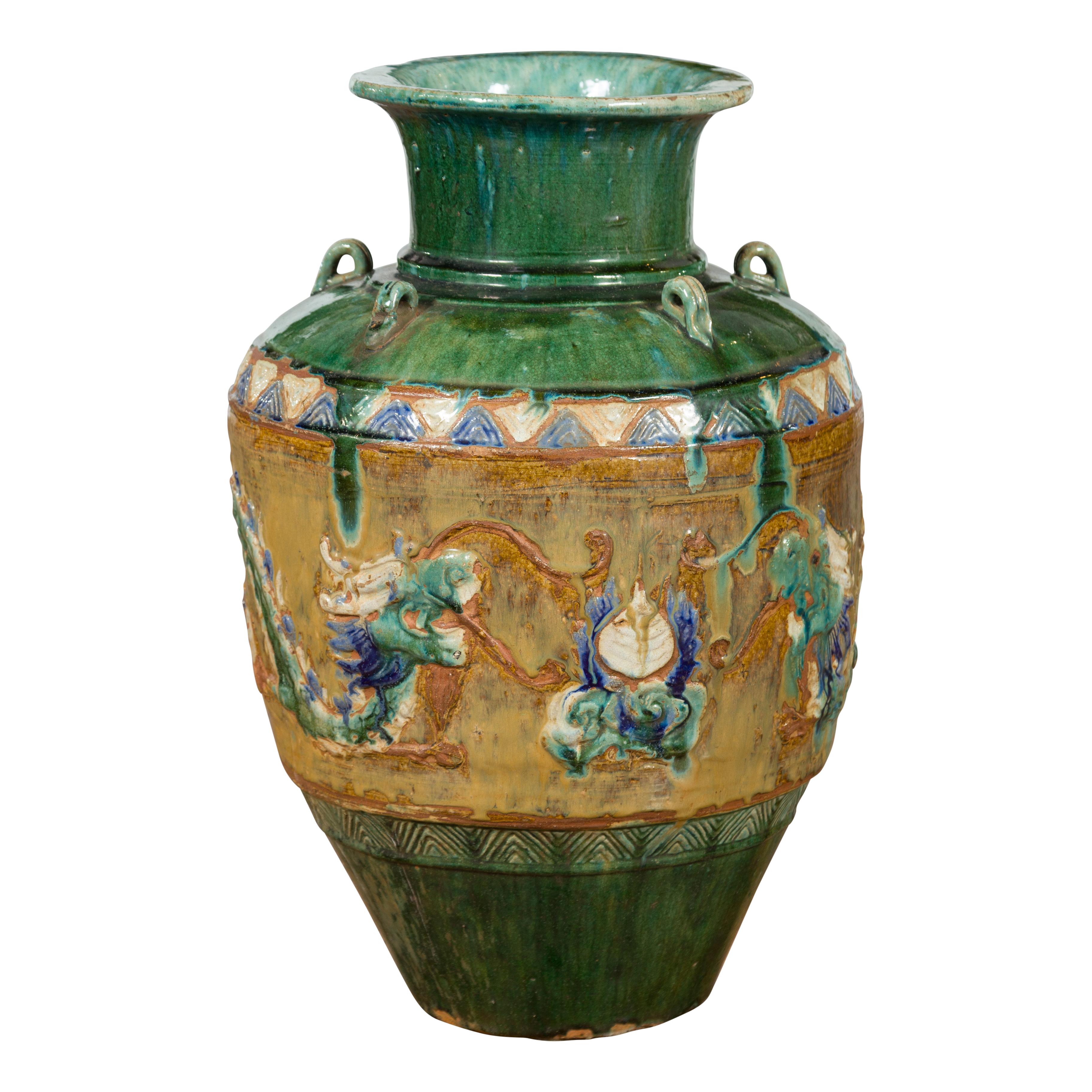 An antique Vietnamese Annamese green water jar from the 17th century, with dragon motifs and petite loop handles. Created in Vietnam during the 17 century, this green glazed Annamese Martaban vase is adorned with a series of petite loop handles