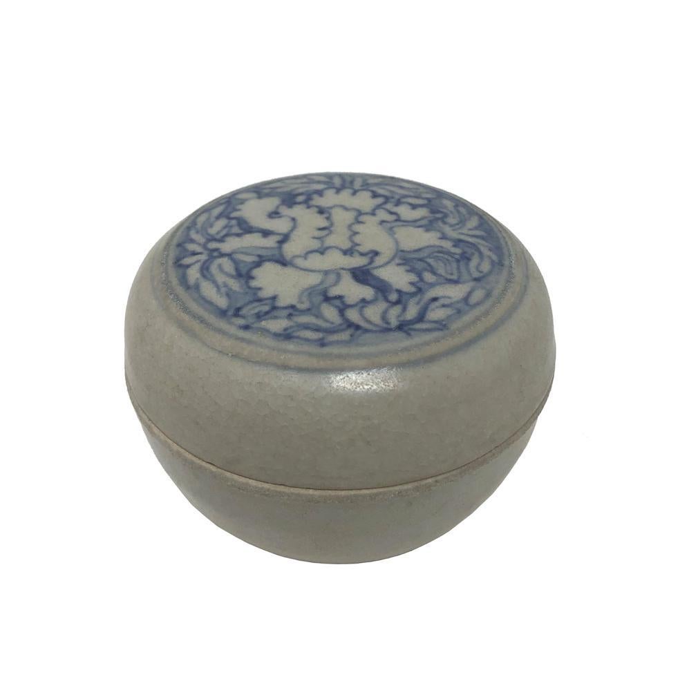 Annamese Blue and White Ceramic Box, Chu Dau kiln, Vietnam, circa 1500. A covered flat top circular box with lid decoration in under glaze cobalt blue of a peony blossom with leafy blue background within circular bands, the body glazed clear except