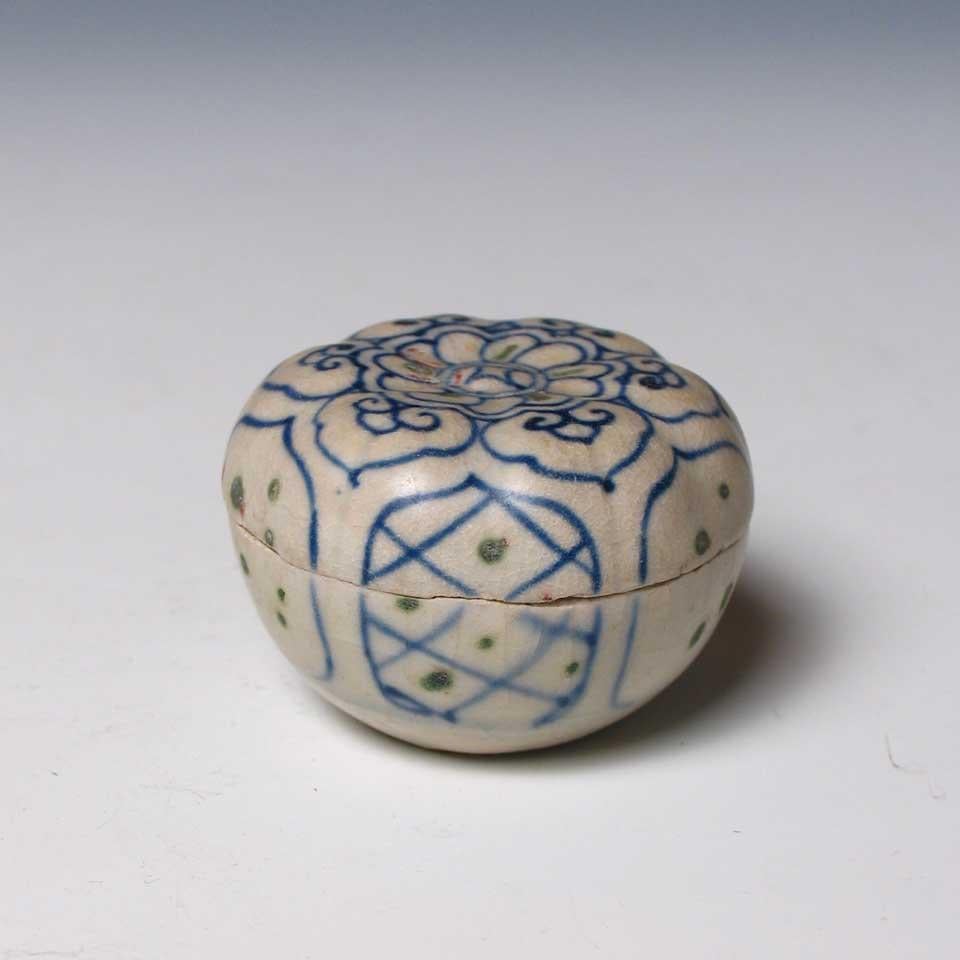 Annamese Molded Blue and White Ceramic Box, Chu Dau kiln, Vietnam, circa 1500. The cover delicately decorated with a central floral medallion from which radiate six conjoined ruyi lappets, the sides with six lotus petal reserves containing
