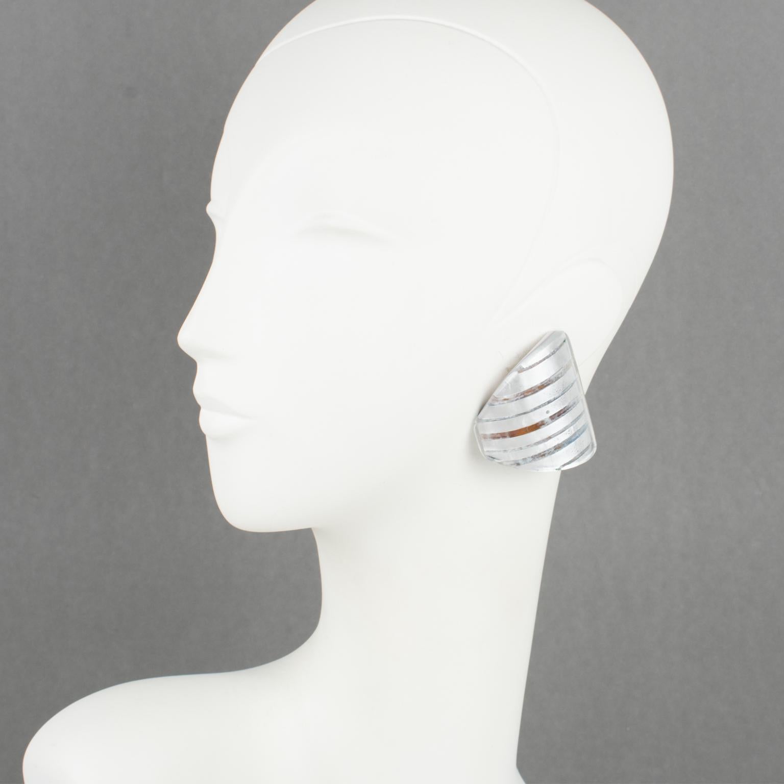 These lovely Anne and Frank Vigneri Lucite clip-on earrings feature a dimensional curved triangle design. The earrings are built with multilayer Lucite, white colored background topped with transparent Lucite with embedded silver foil and