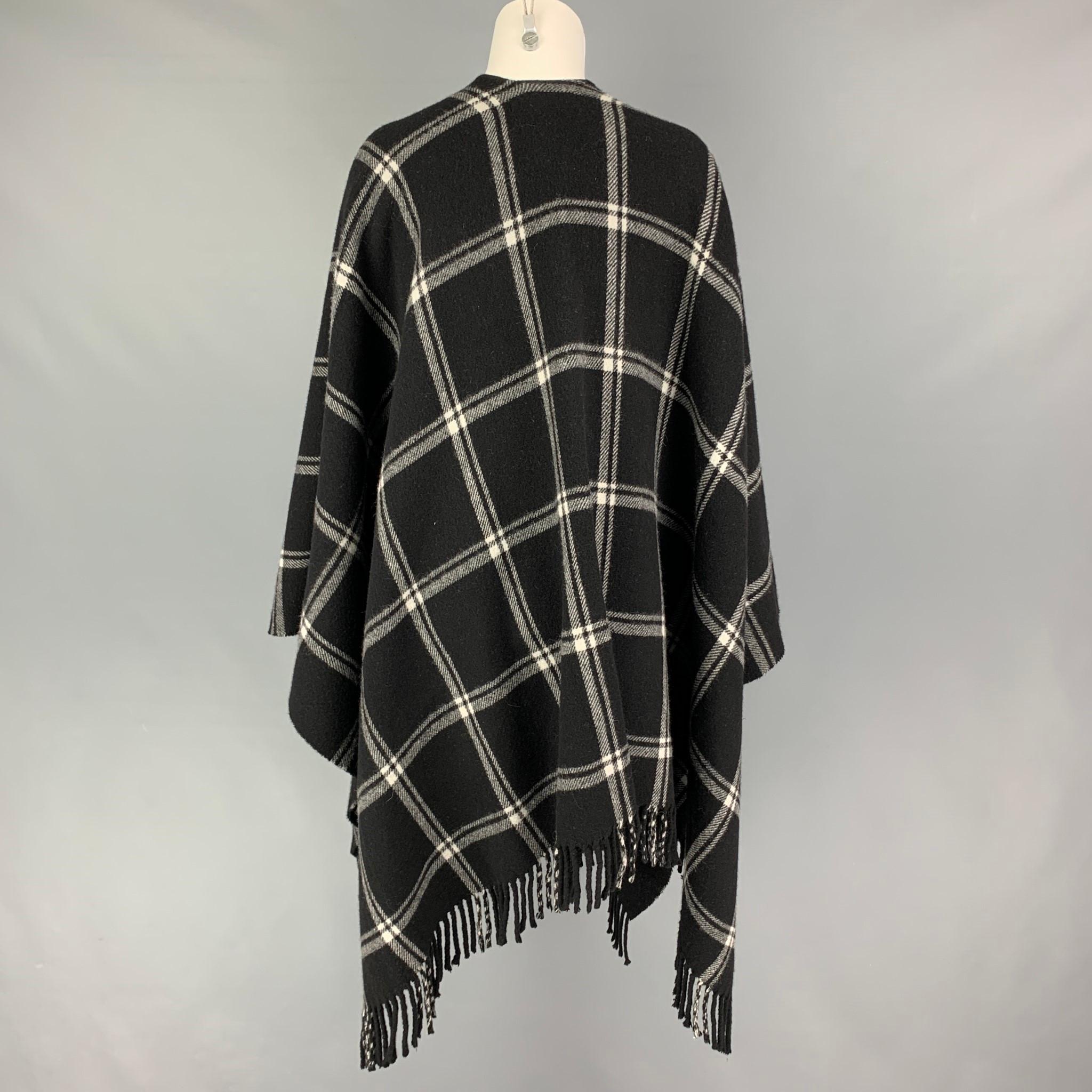 ANNE FONTAINE cape comes in a black & white plaid wool featuring a fringe trim. Made in Italy. 

Very Good Pre-Owned Condition.
Marked: One Size

Measurements:

Length: 33 in. 