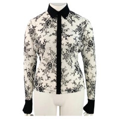 Blusa de Anne Fontaine Solly, blanca y negra, con encaje calado y ribetes en contraste. Talla indicada: FR 46