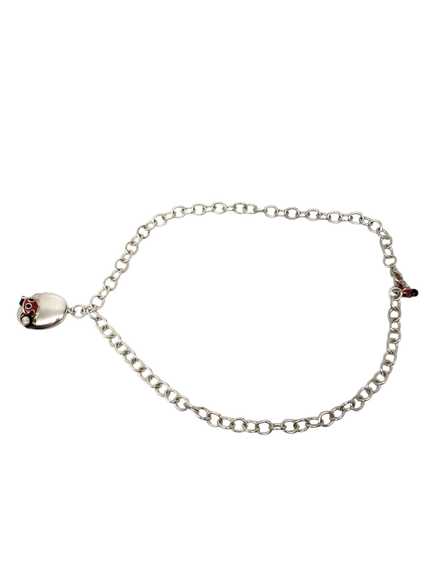 Anne Geddes Sterling Silber Marienkäfer Medaillon Halskette-

Diese skurrile Halskette von Anne Geddes besteht aus einem ovalen Medaillon mit einem Marienkäfer aus roter und schwarzer Emaille, das sich öffnen lässt, um Platz für 2 kleine Fotos an