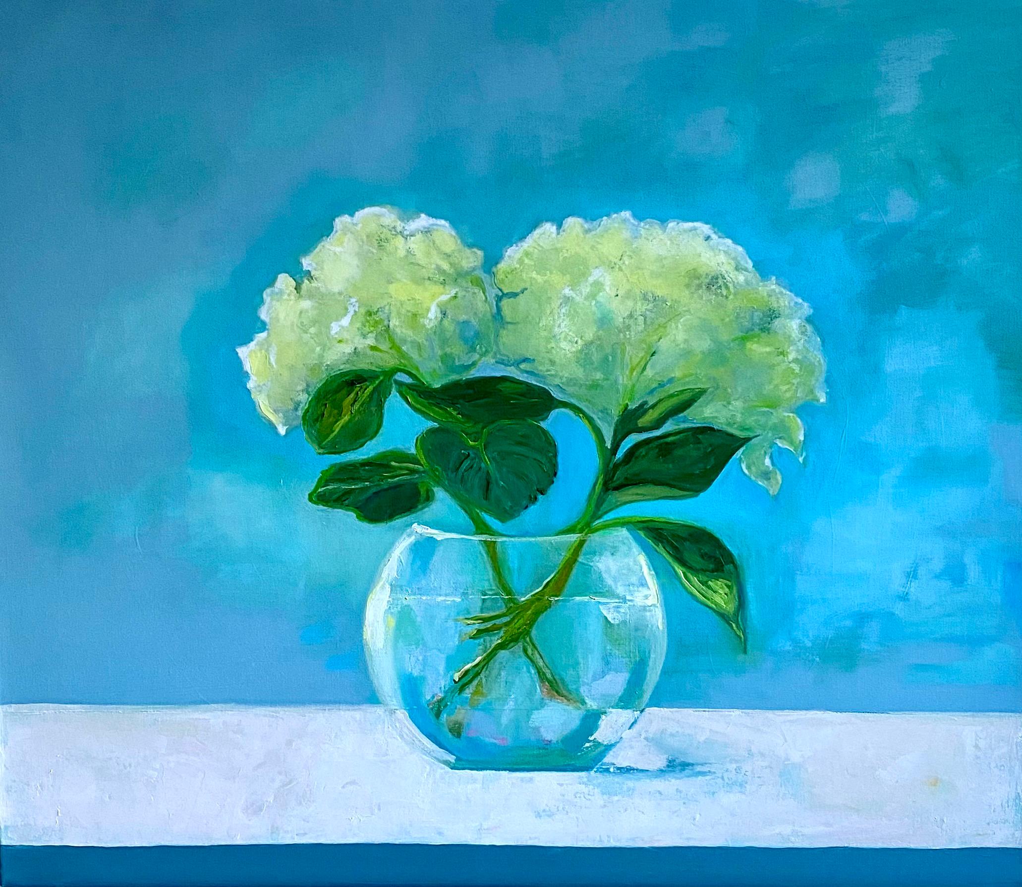 Anne Harney Still-Life Painting - "Hydrangeas" oil painting of two white hydrangeas and a clear vase blue behind