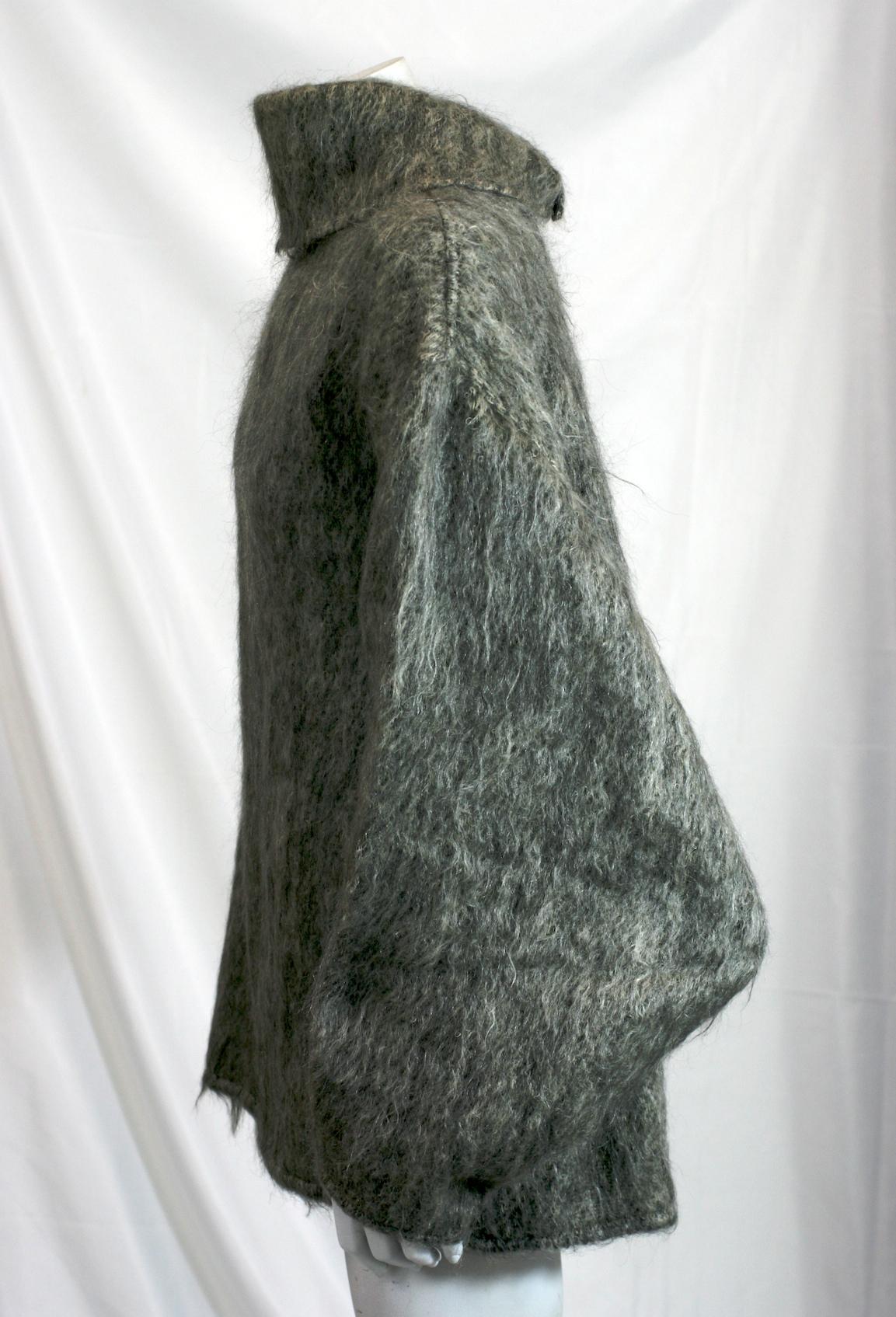 Chemisier en mohair gris brossé d'Anne-Marie datant des années 1980. Grand col et manches profondes avec coudes pointus caractéristiques. Gros grain noir avec boutons-pression au dos. Le col est muni de boutons-pression à la base, ce qui permet d'en