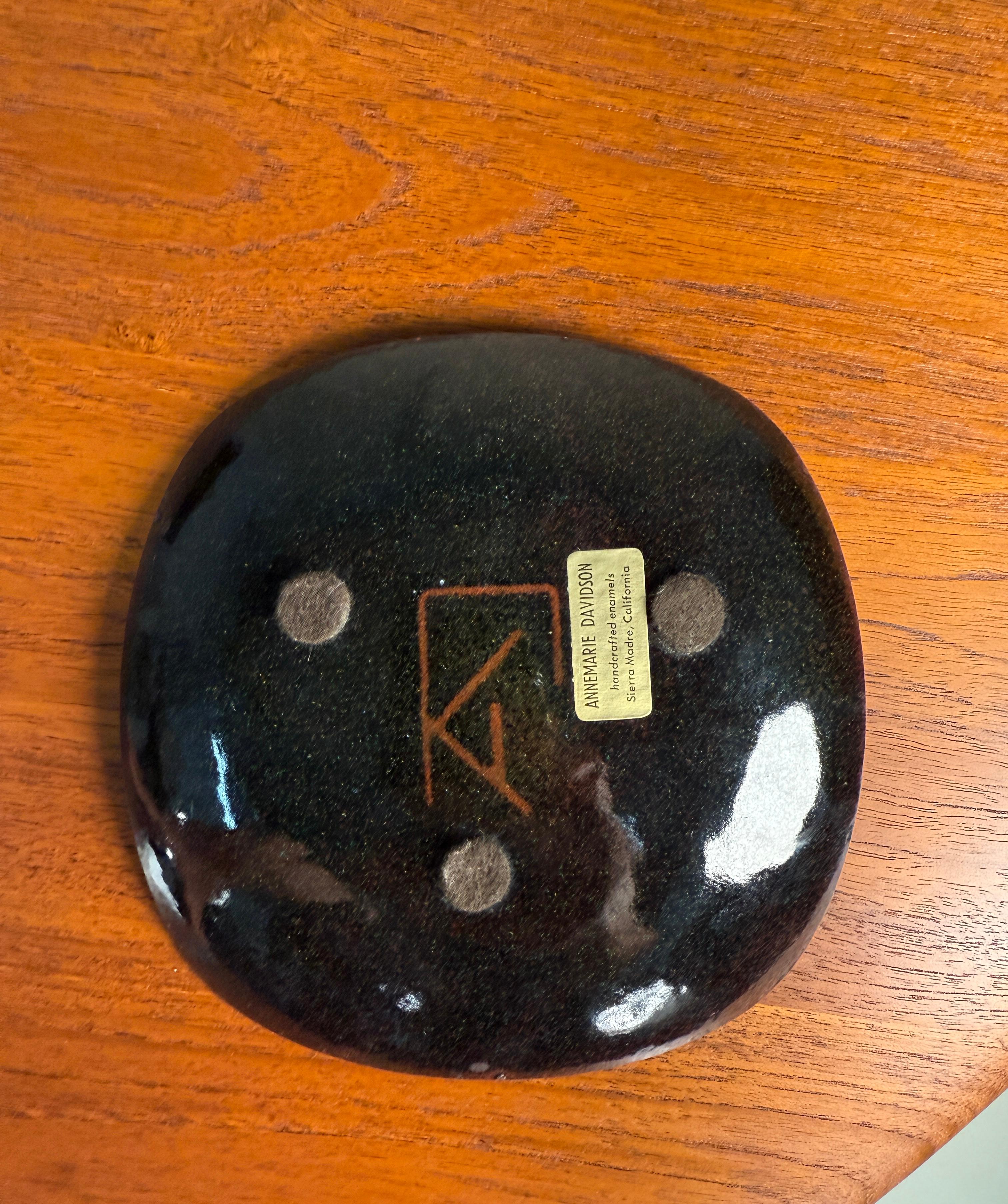 A wonderful enameled copper plate by Annemarie Davidson of Sierra Madre. The design features incised rays emanating from the famous jewel-like structures offset from the center of plate. This pattern is sometimes known as 