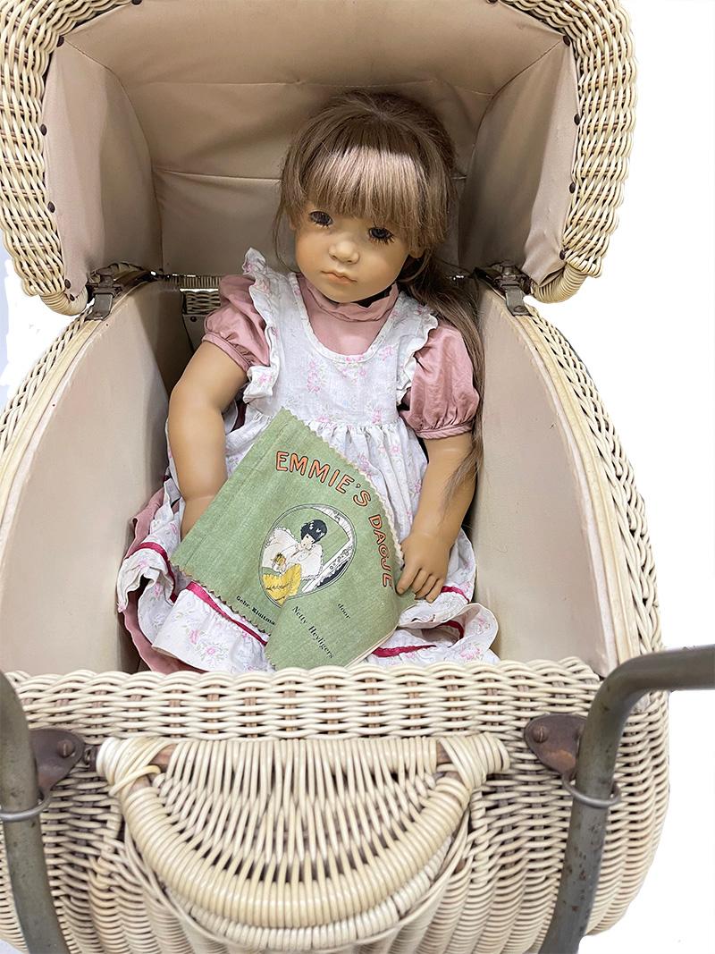 Annette Himstedt doll Neblina 1991/1992 with children's doll pram

A Mid 20th Century children's doll pram with an Annette Himstedt doll.
Neblina is from the 1991 / 1992 collection of Annette Himstedt. The doll and the doll's pram are used and show