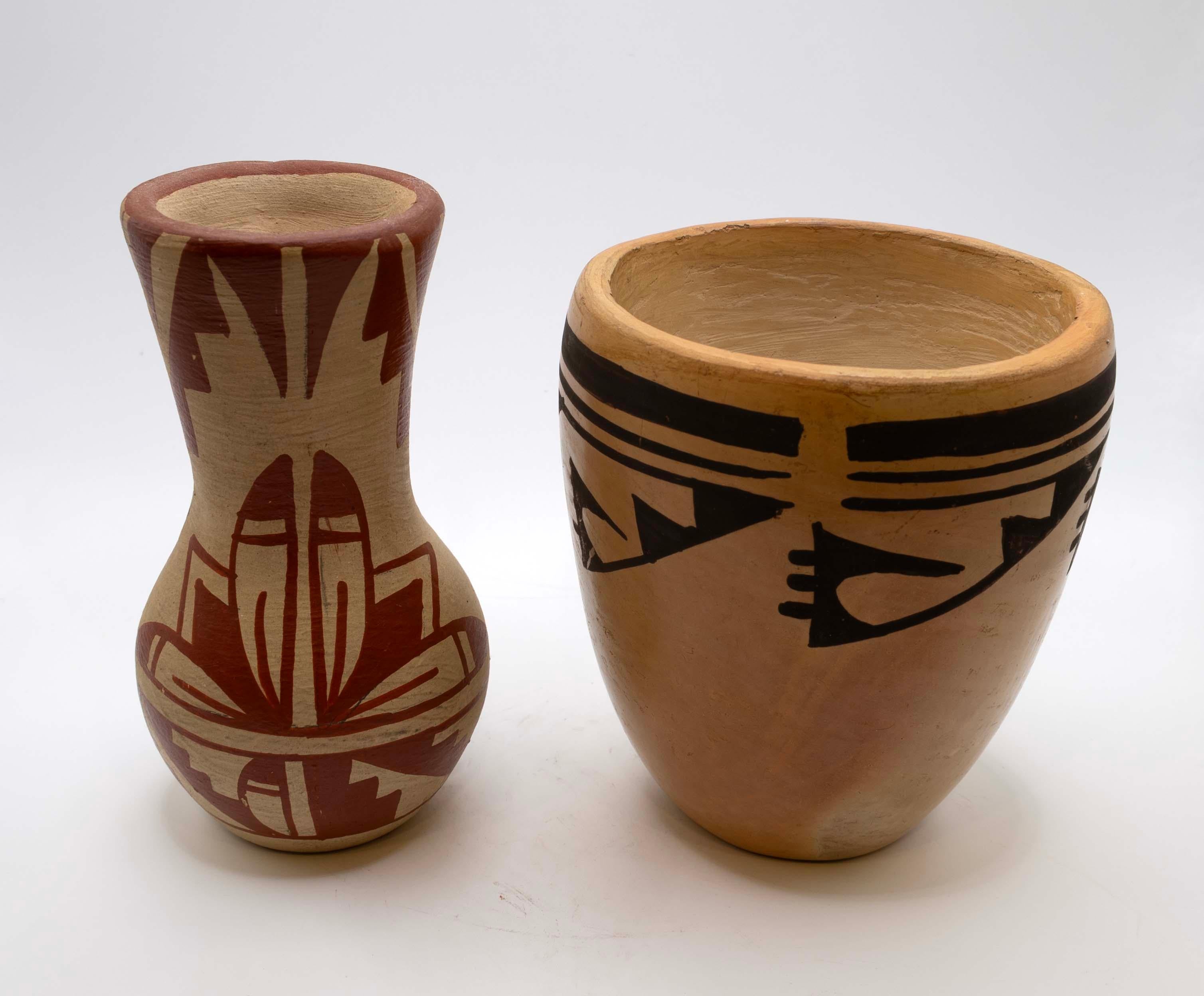 A set of Southwest Pueblo pottery from New Mexico. Each vessel is signed by Annette Silas (Hopi) & F. Waquie (Jemez). The vessels are fired earthenware with highly stylized geometric designs in red and stark black and white. Jemez pottery has been