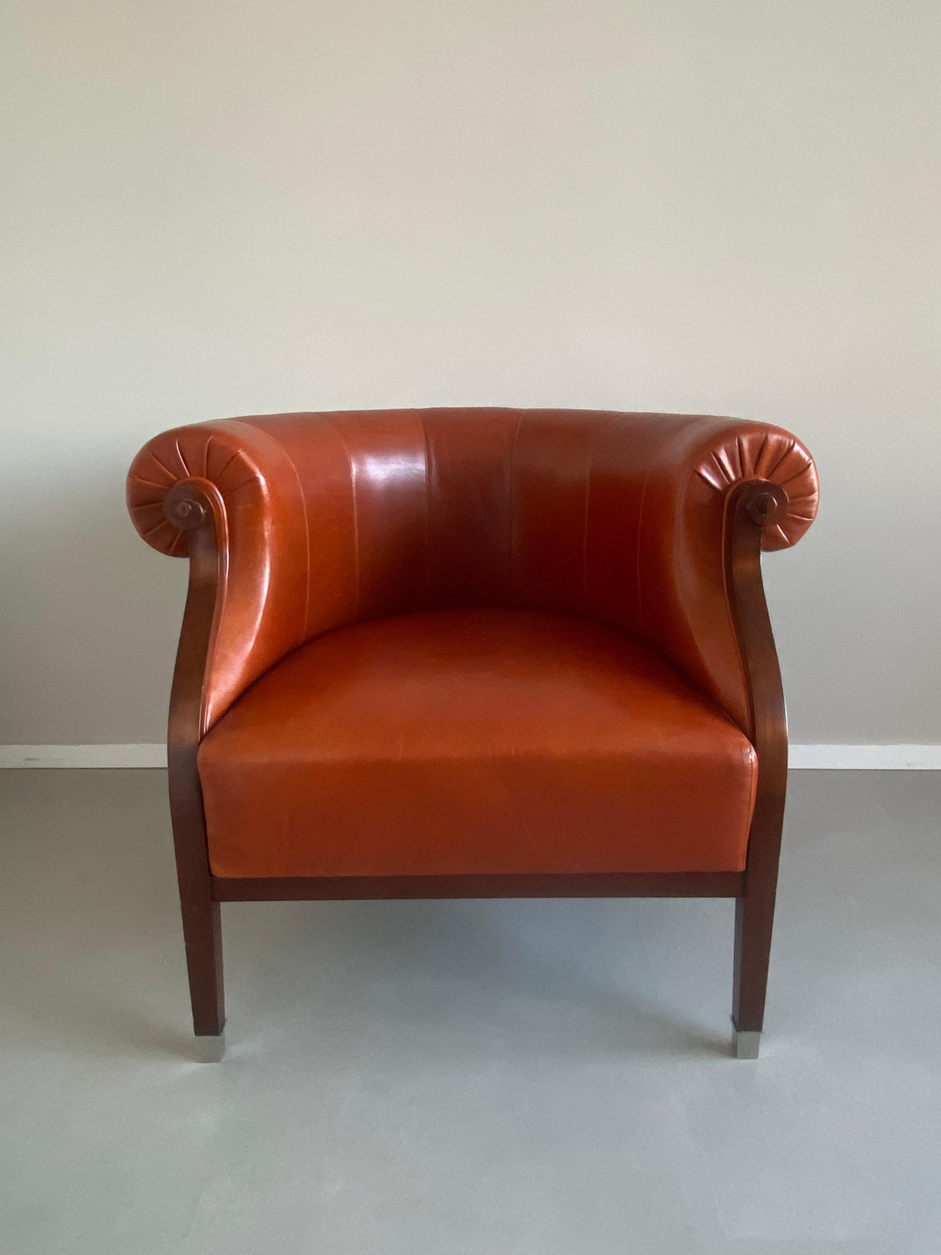 Eleganter italienischer Sessel, der von dem berühmten Annibale Colombo hergestellt wurde. Der Stuhl hat ein Untergestell aus Kirschholz, eine Sitzfläche, Rücken- und Armlehnen aus cognacfarbenem Leder und Details wie Füße aus Edelstahl. Dieses