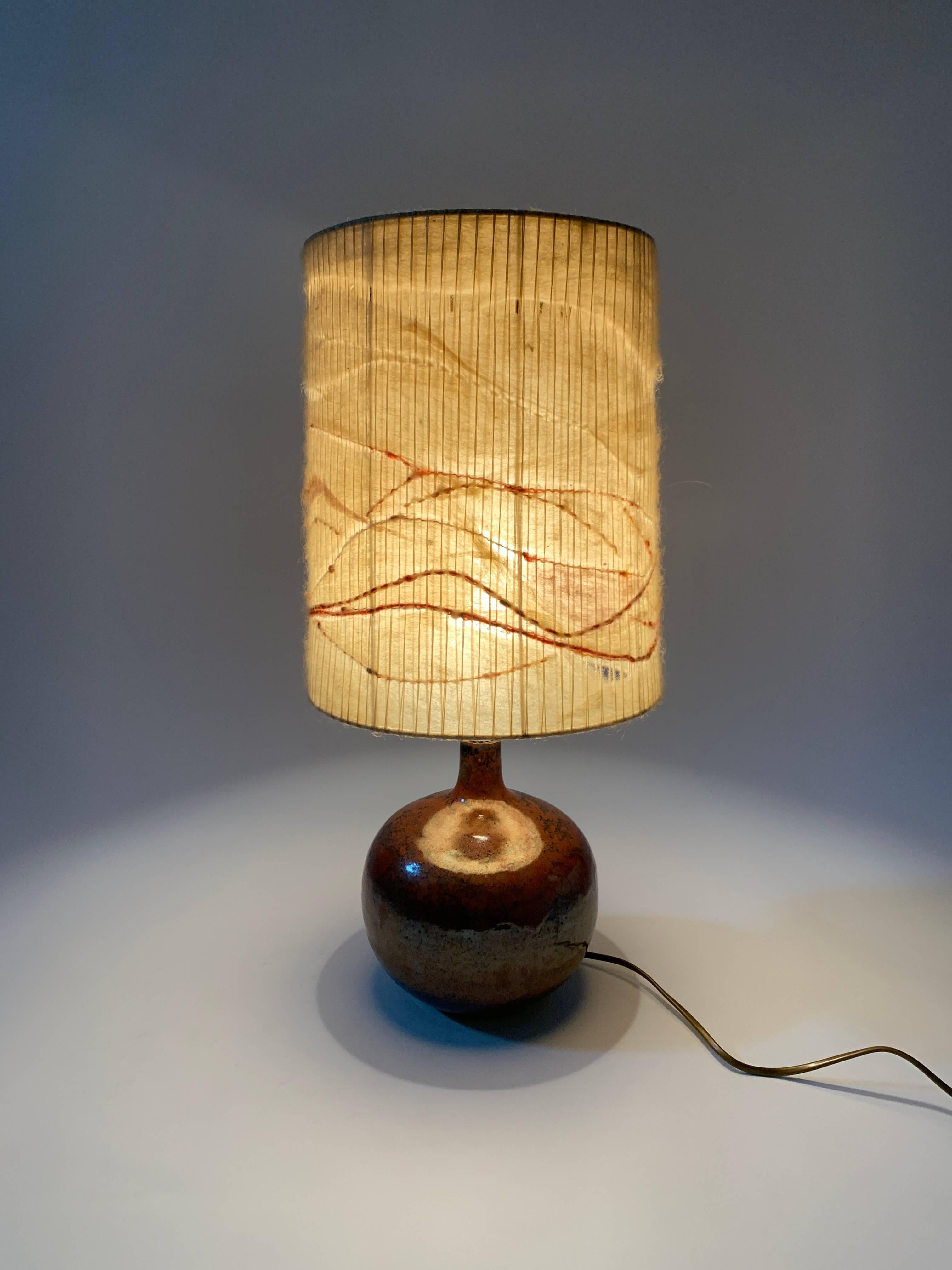 Annie Maume (1945 - )
Schule La Borne.

Fein emaillierte Steingutlampe, verziert mit einem zarten Dekor aus Asche-Emaille in subtilen Schattierungen von Weintrub, Braun und Schwarz.
Die Lampe mit ihrem originalen Lampenschirm ist ein seltenes