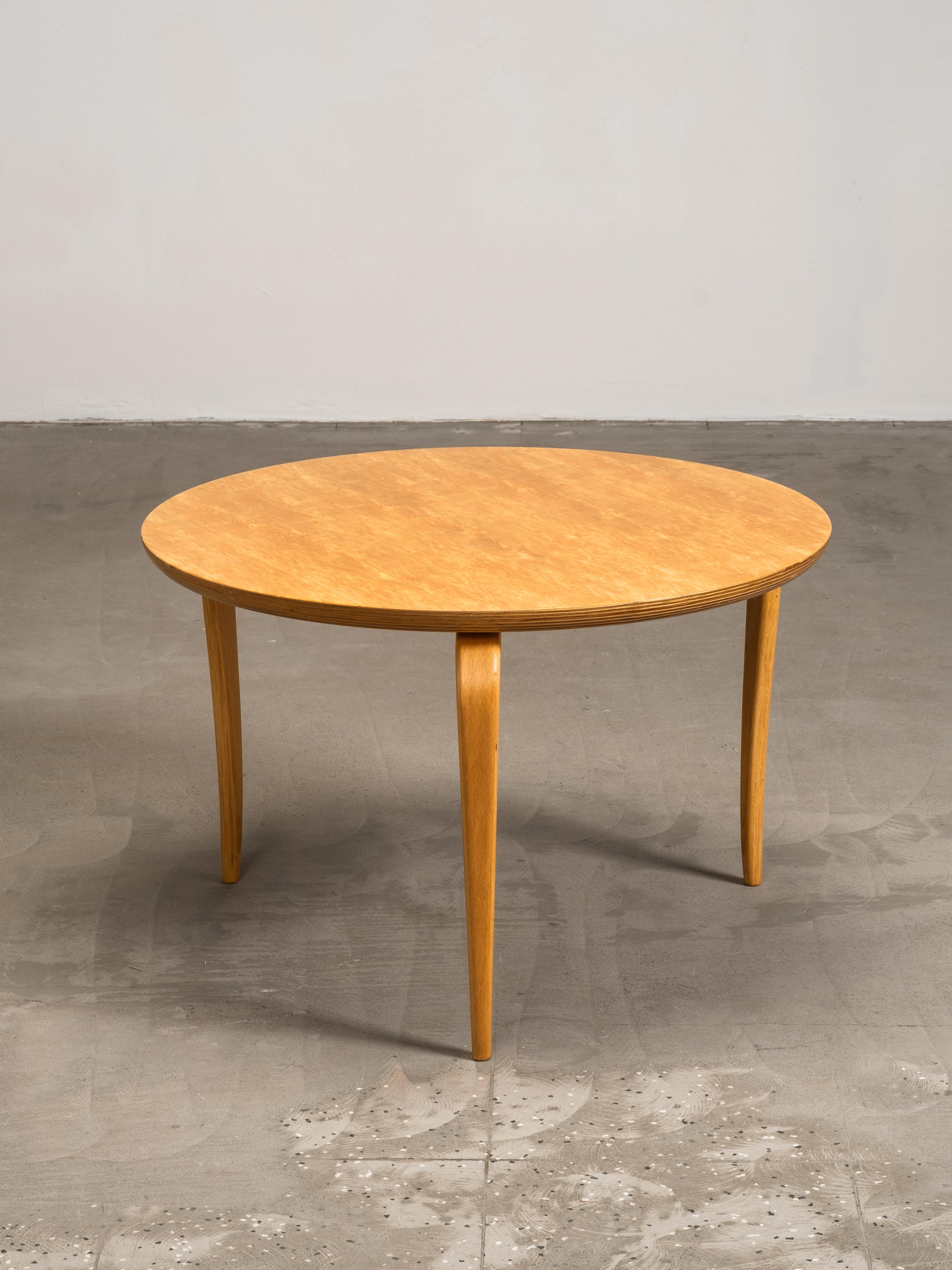 A round curly birch-veneered “Annika” coffee table designed by Bruno Mathsson and produced by Dux in Sweden. The table has a light, functional form with a circular top and slender, tapered beech legs. The curly birch veneer shows expressive,
