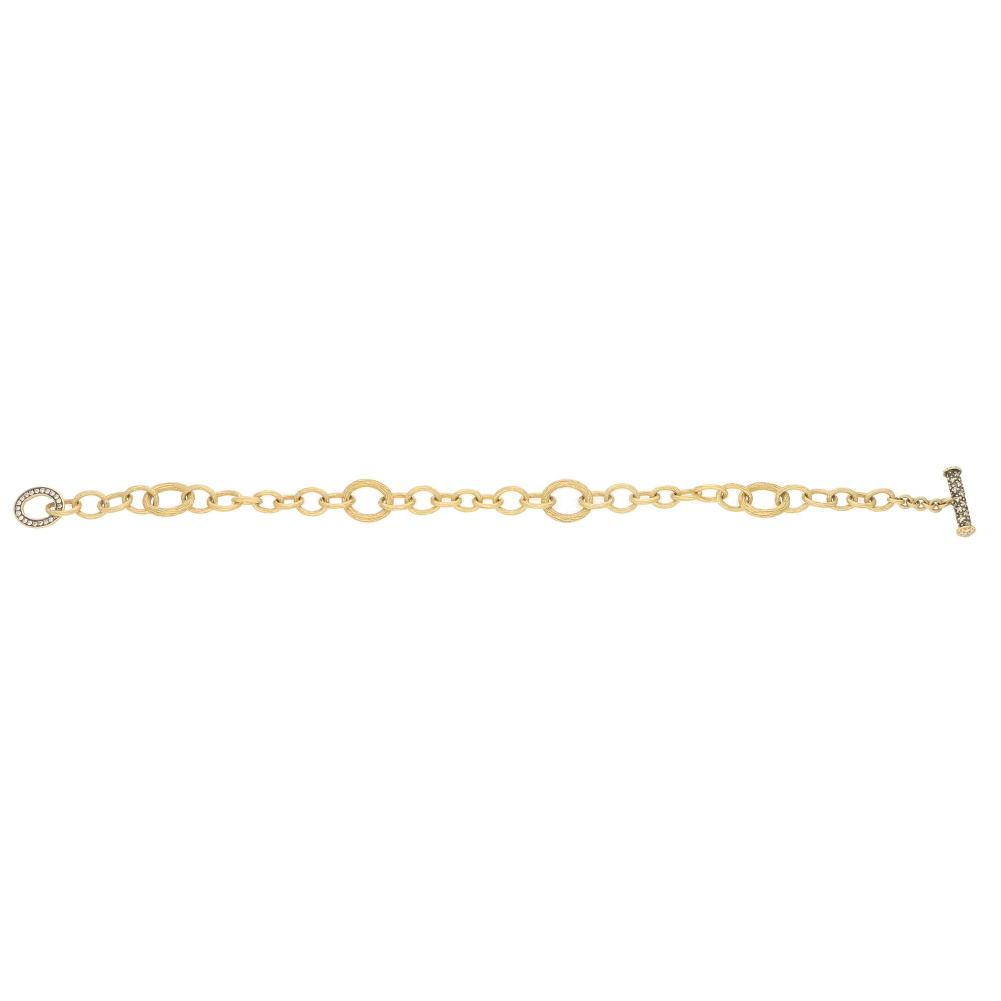 A modern take on the traditional charm link bracelet. A signed Annoushka bracelet set in 18 carat yellow gold. The bracelet is composed of 34 graduating brushed gold hoops with a simple yet beautiful diamond set clasp.

The bracelet measures exactly