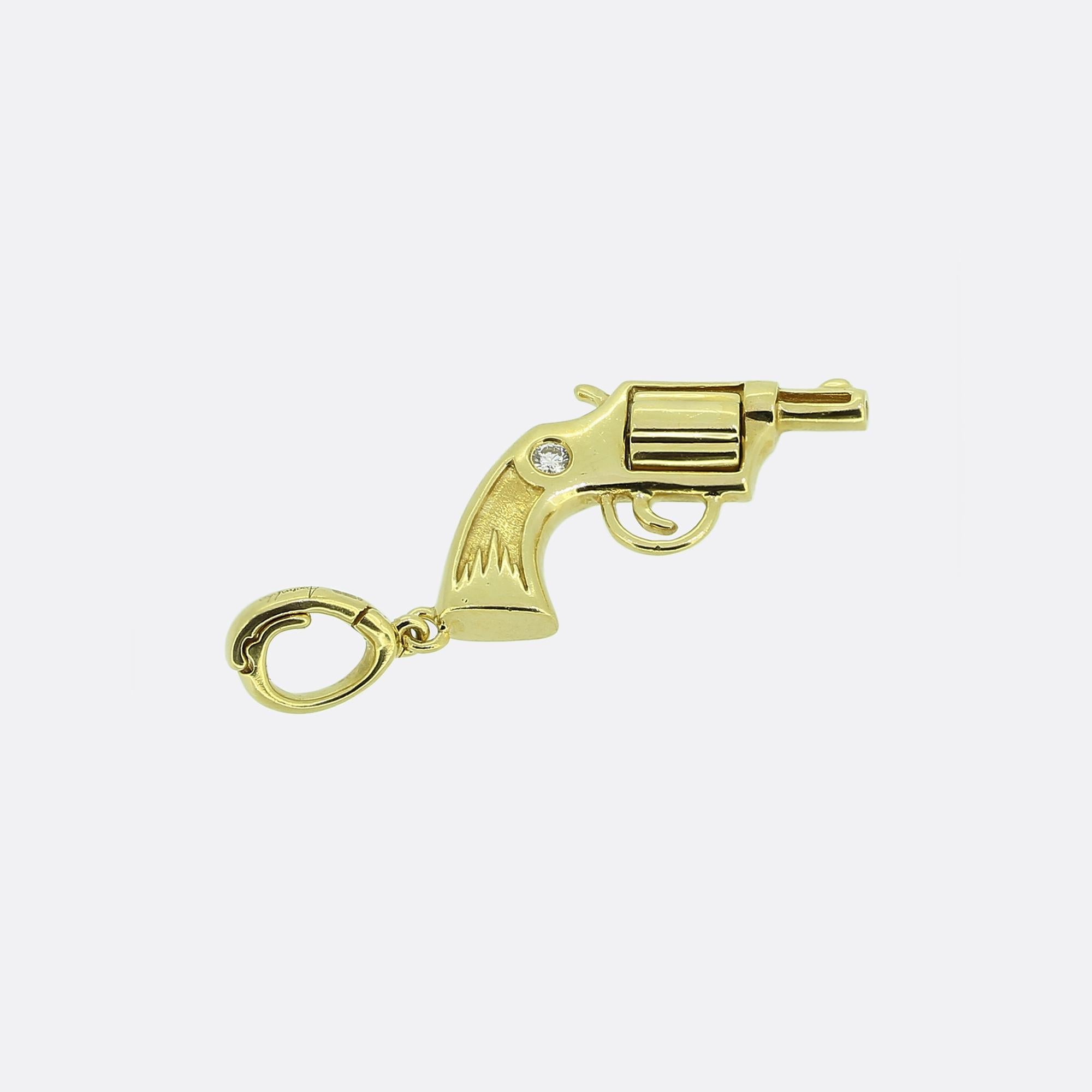 Here we have an 18ct gold charm from one of Britain's most esteemed modern jewellery designers, Annoushka. Meticulously crafted into the shape of revolver, the charm features a polished finish with a tiny white diamond at each side and a chamber