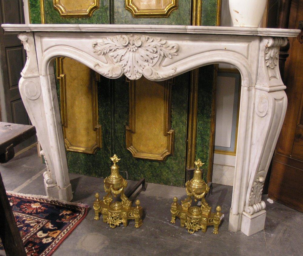 Ancient fireplace in white Carrara marble, richly carved with a floral shell on the pediment and moved legs, large very beautiful scrolls, produced in the 18th century in France, certainly from a noble palace, from the reception rooms, carved by
