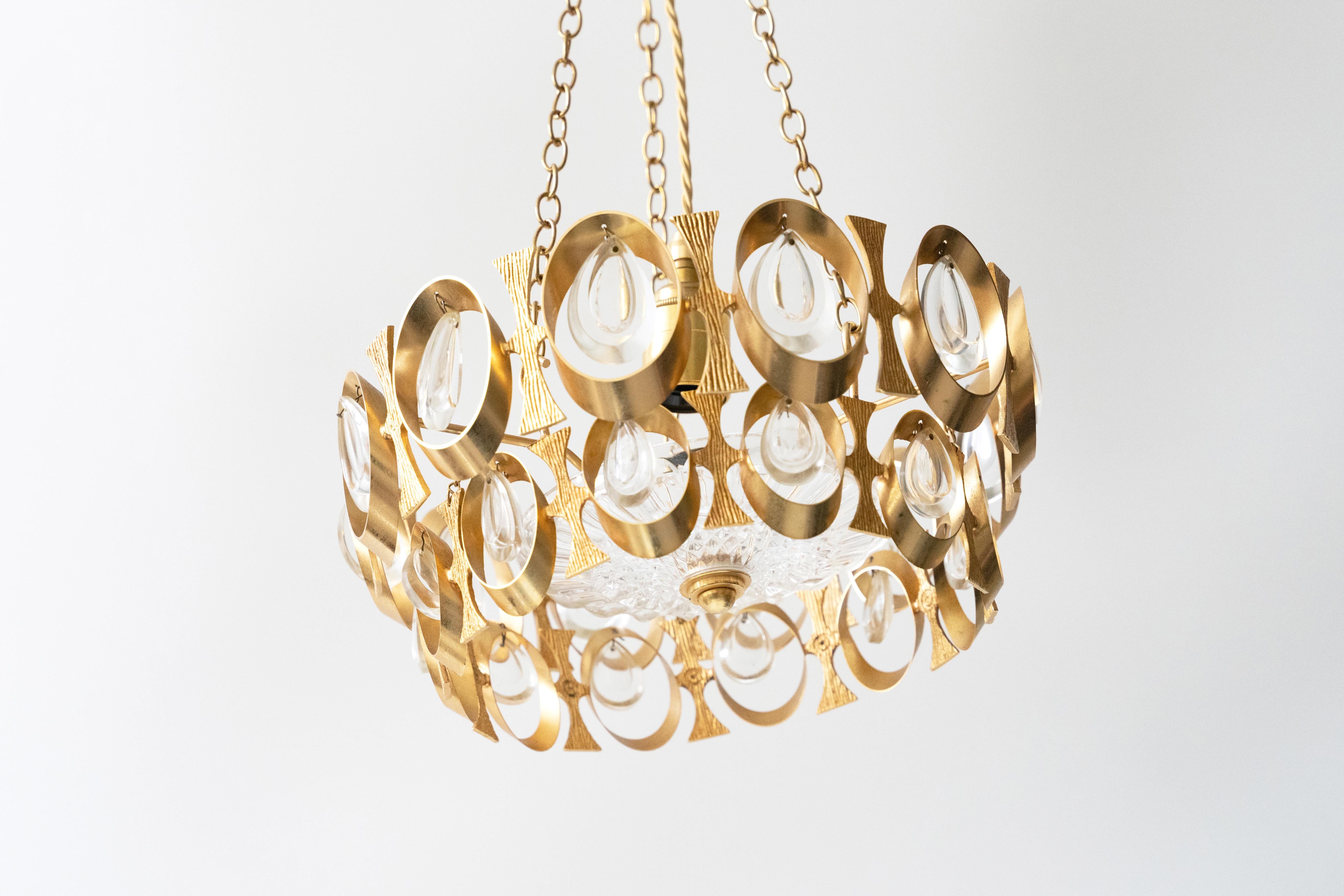 THIS ITEM CAN BE PICKED UP FROM LONDON OR PARIS . WE OFFER FREE SHIPPING IN PARIS AND LONDON.

This chandelier exemplifies 20th century elegance and sophistication. Designed with a striking gold-finished base, it features an array of intricate, oval