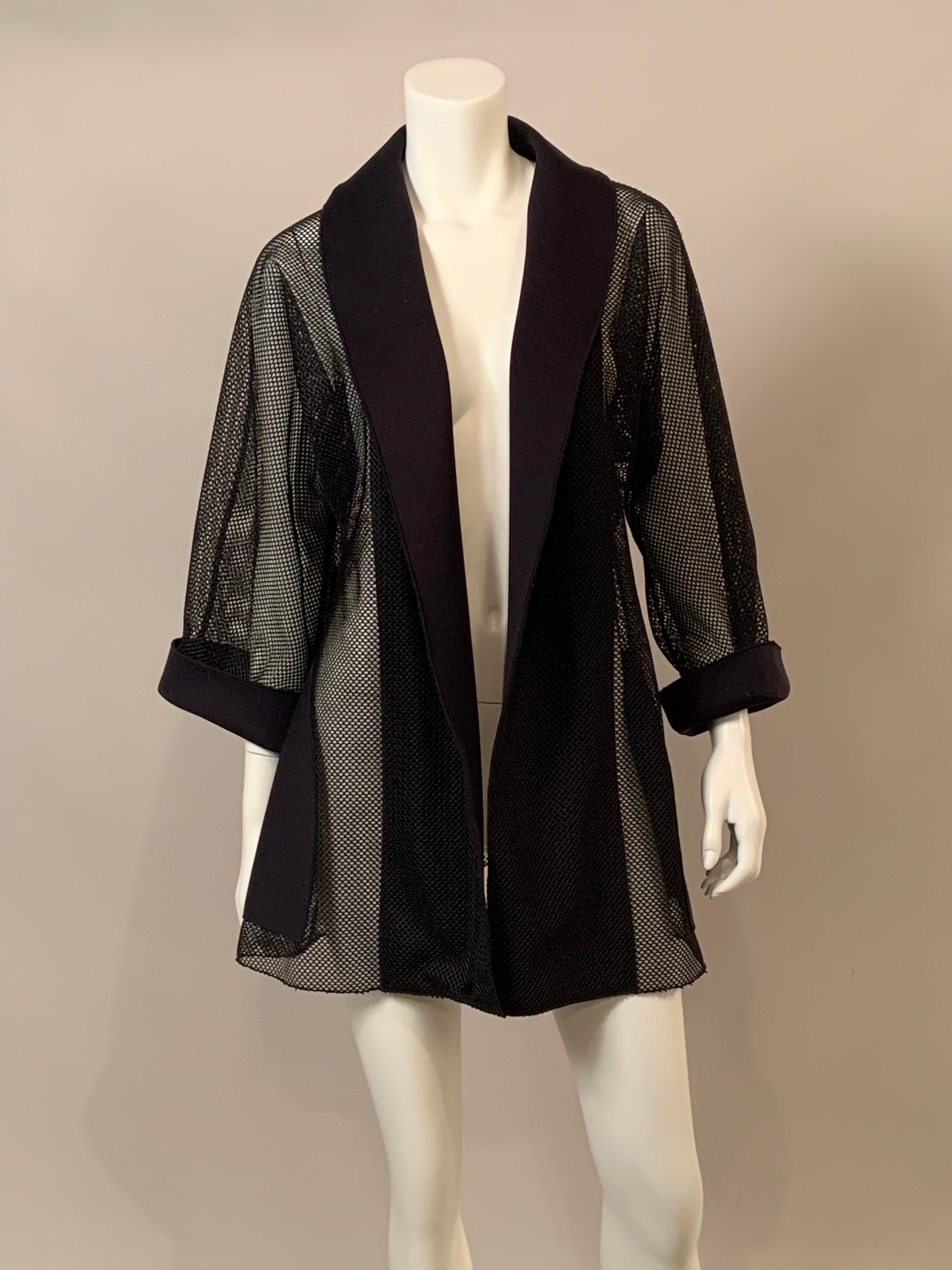 This black mesh or open work jacket has great style.  Wide lapels, pockets and deep cuffs in a black synthetic fabric add a touch of formality to the see through garment.  There are no labels so please check the measurements.  The jacket is in