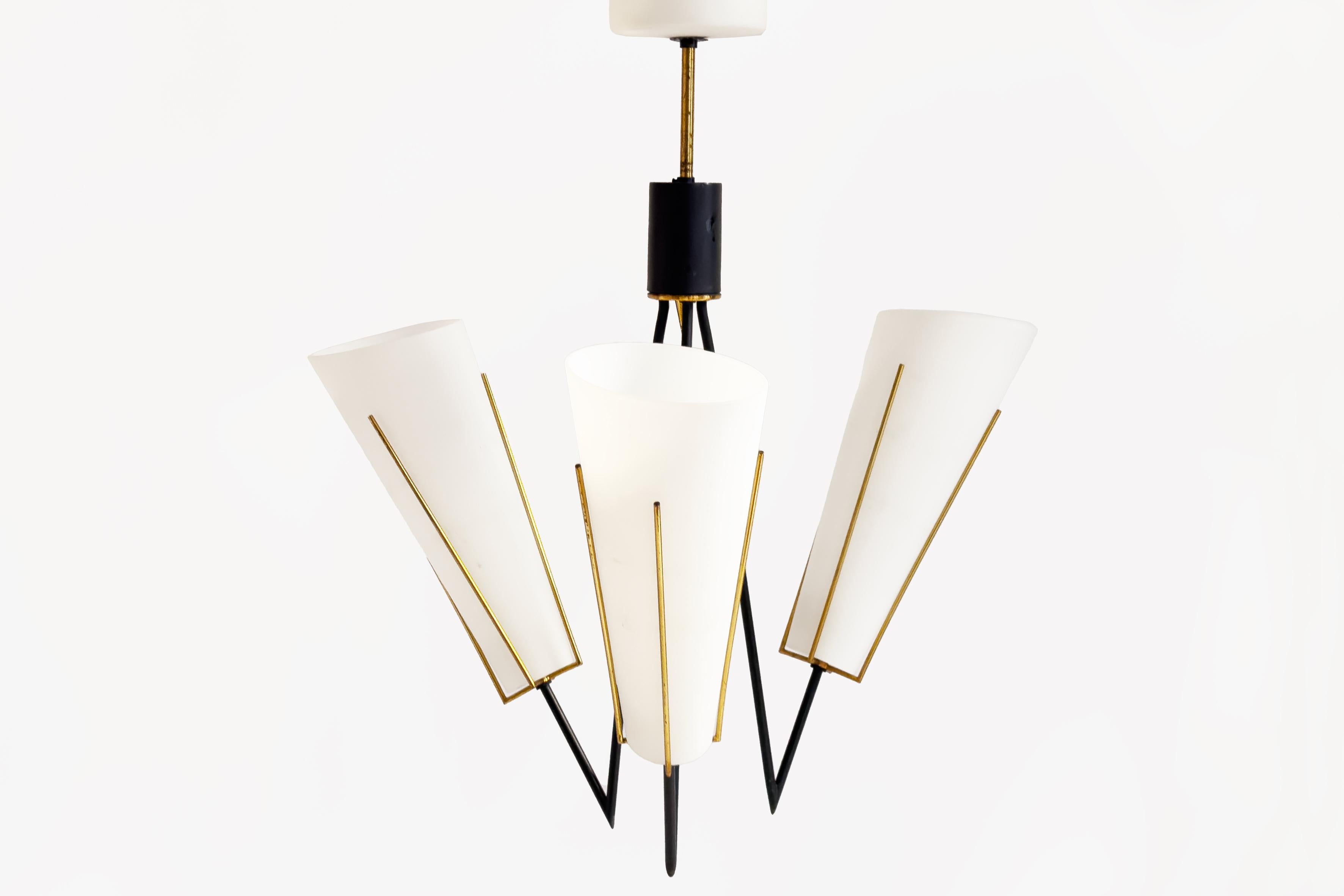 This elegant Danish mid-century suspension lamp, dating from the 1960s, exemplifies the refined craftsmanship and timeless aesthetics of Scandinavian design. The fixture features a black lacquered metal and brass structure, with three gracefully