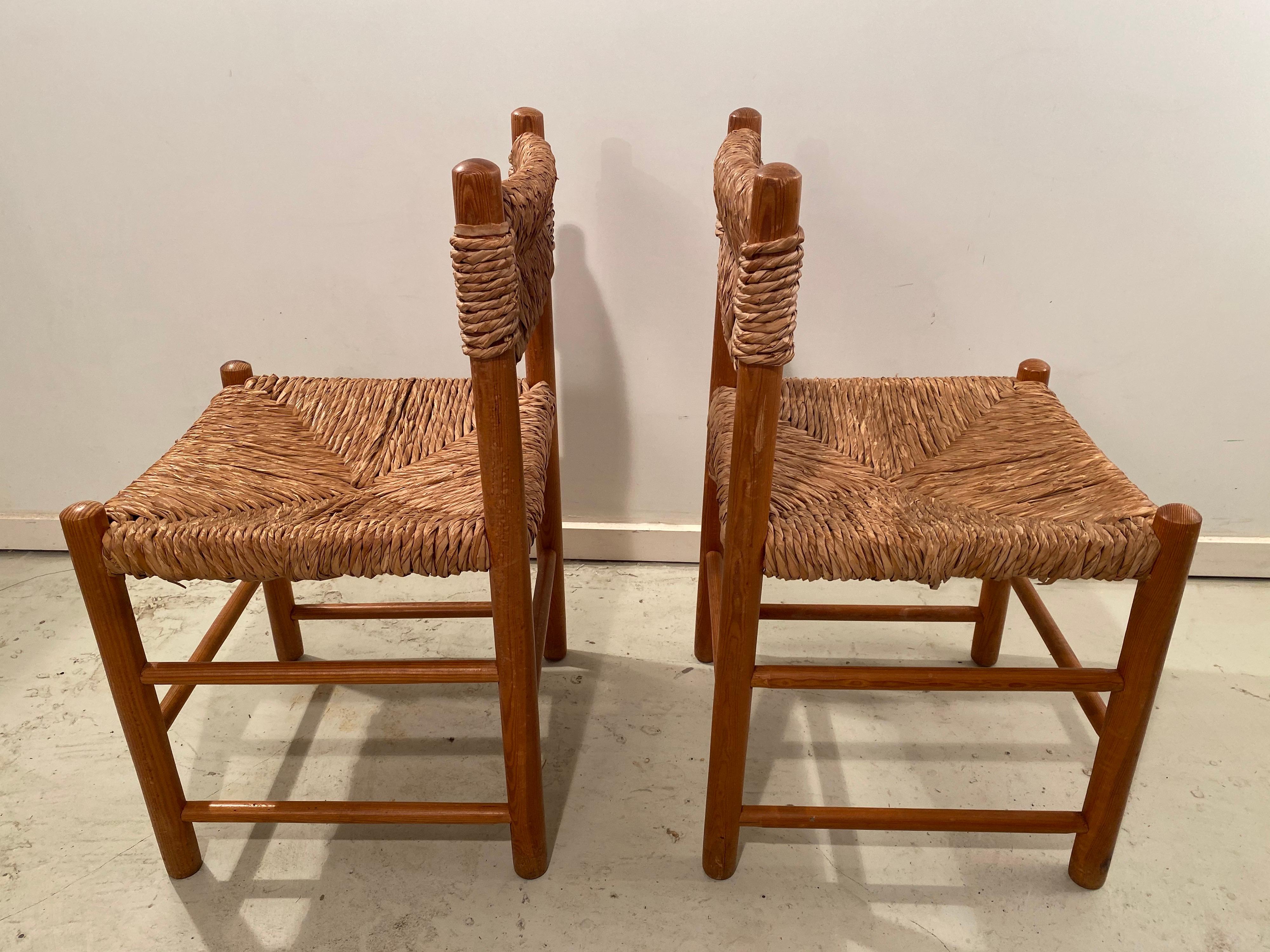Beautiful pair of dining chairs from the Dordogne series by Charlotte Perriand for Sentou. The wicker seat and back of both chairs are in good vintage condition.
 