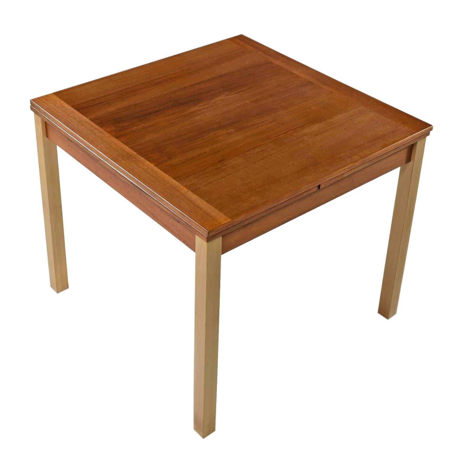 Made by Ansager Mobler, circa 1970s. The contrasting butcher block style wood grain on the leafs enhance the simple and Minimalist nature of this Scandinavian design. Teak top with light colored beechwood legs. Consider pairing this dining table