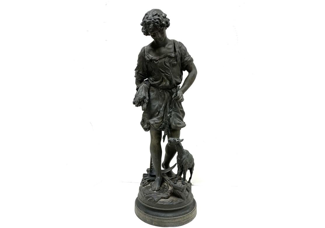 Charming spelter figure of a boy holding a scythe and a cluster of wheat sheaves as he dangles a wheat branch to the goat who is feeding. The figures are surmounted on a round plinth base. The interior of the base is stamped Ansonia Clock Co. as
